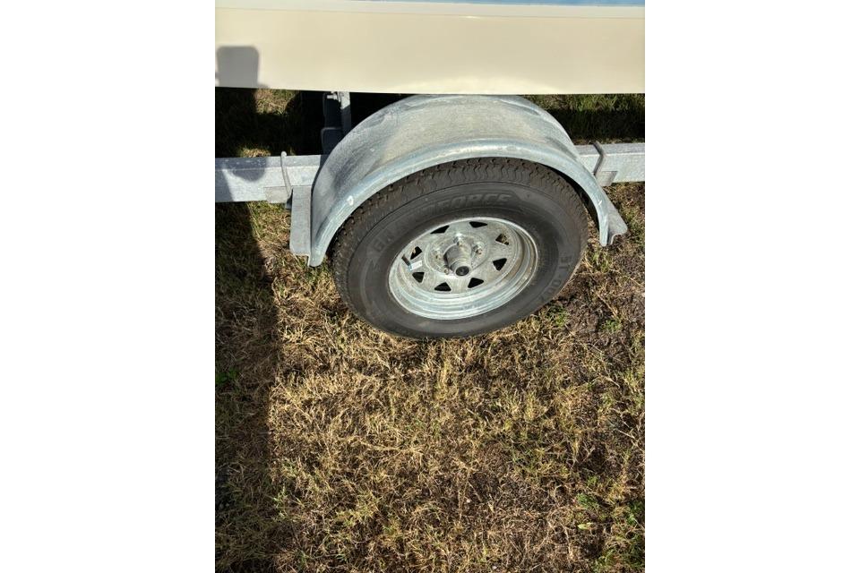 Trailer wheel of a 2005 Hydra-Sports Lightning 180 CC on grass.