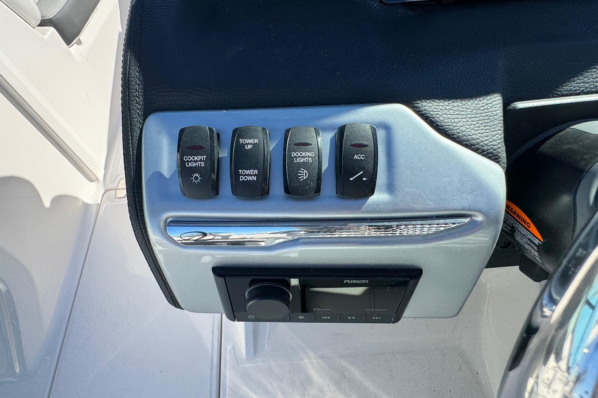 Control panel of 2026 Regal 21 OBX boat with labeled switches and audio system.