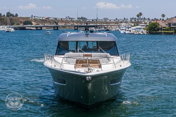 2025 Riviera 645 SUV yacht cruising on a sunny day in a marina.