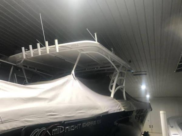 2019 Midnight Express 39 Cuddy boat in storage, partially covered, with visible T-top and antennas.