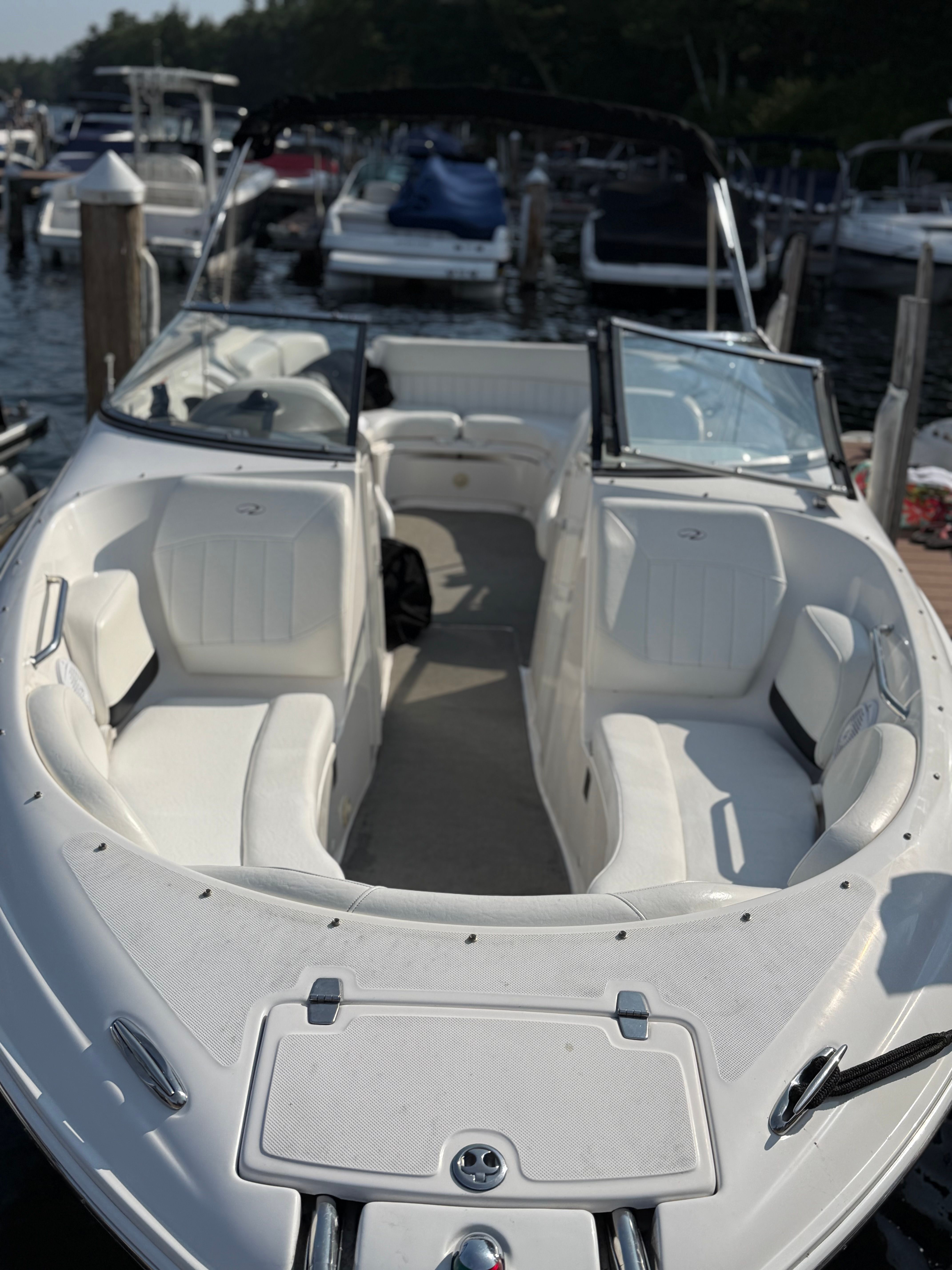 2007 Regal 2400 Bowrider boat with white seating, docked at a marina.