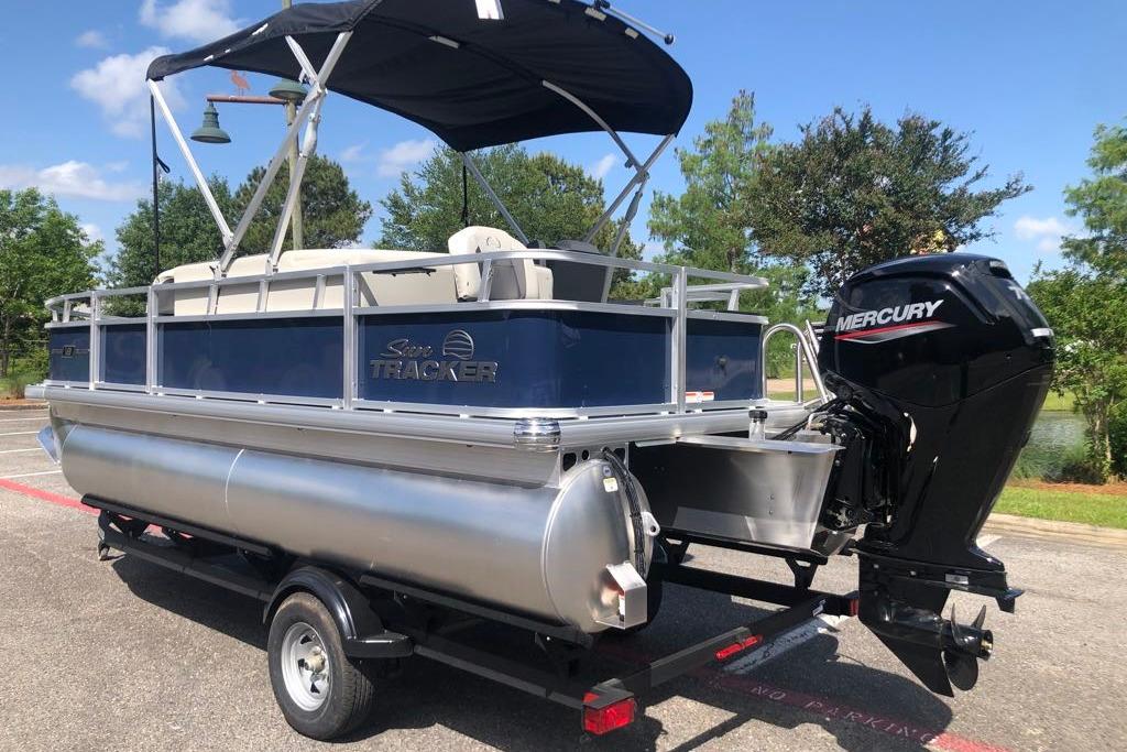 2026 Sun Tracker Bass Buggy 18 DLX pontoon boat with Mercury outboard motor on trailer.