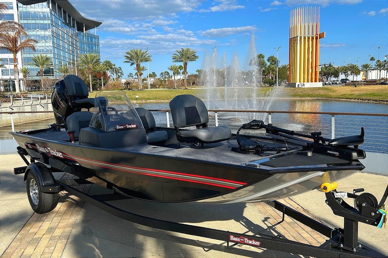 2026 Tracker Bass Tracker Classic XL boat by a fountain, modern building in background.