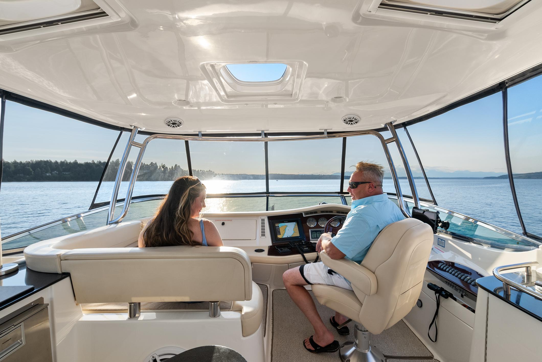 2012 Meridian 541 Sedan interior with two people enjoying a scenic boat ride.
