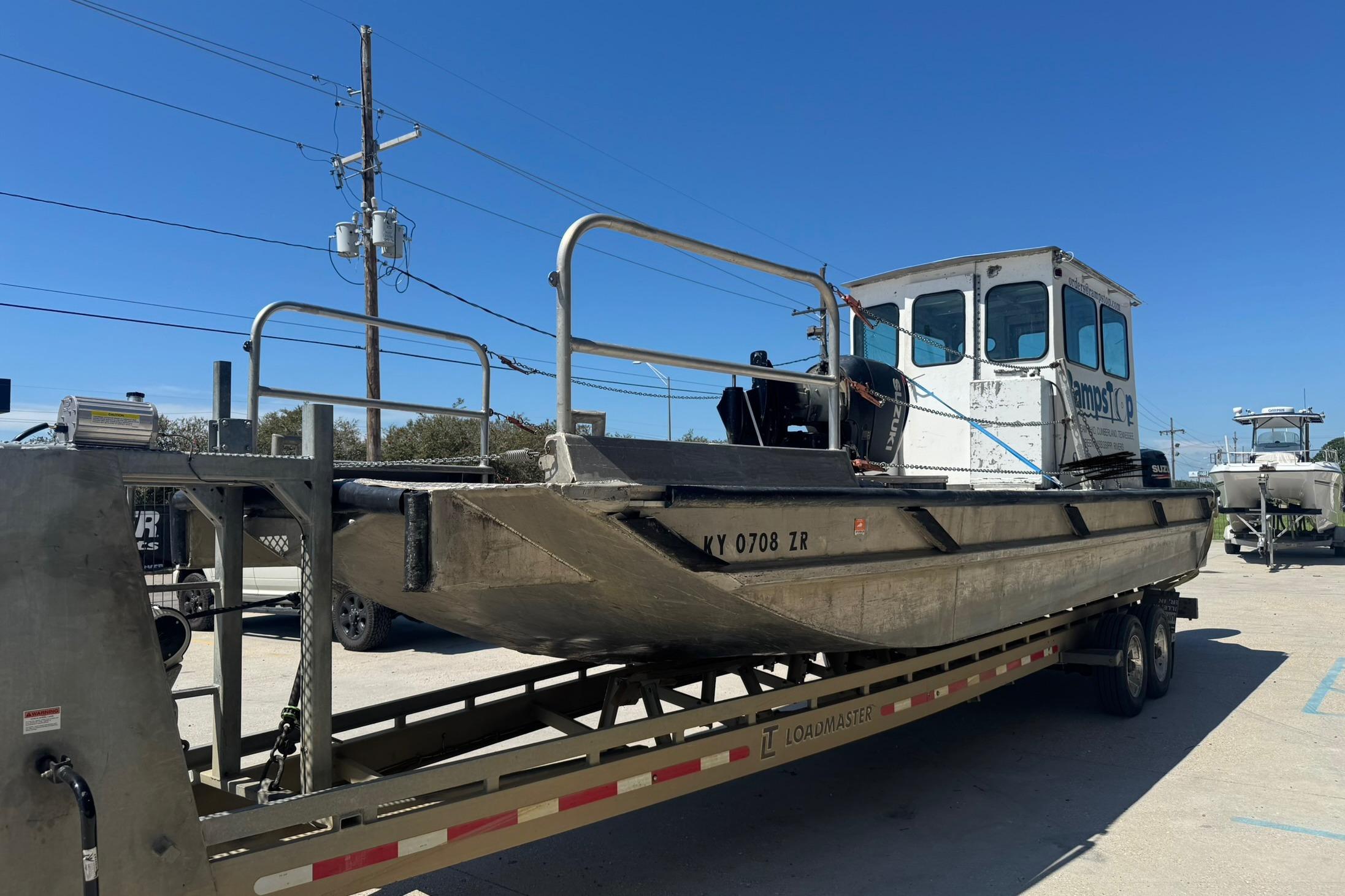 Custom Aluminum Work Boat 33, 2010 model, on a trailer under clear blue sky.