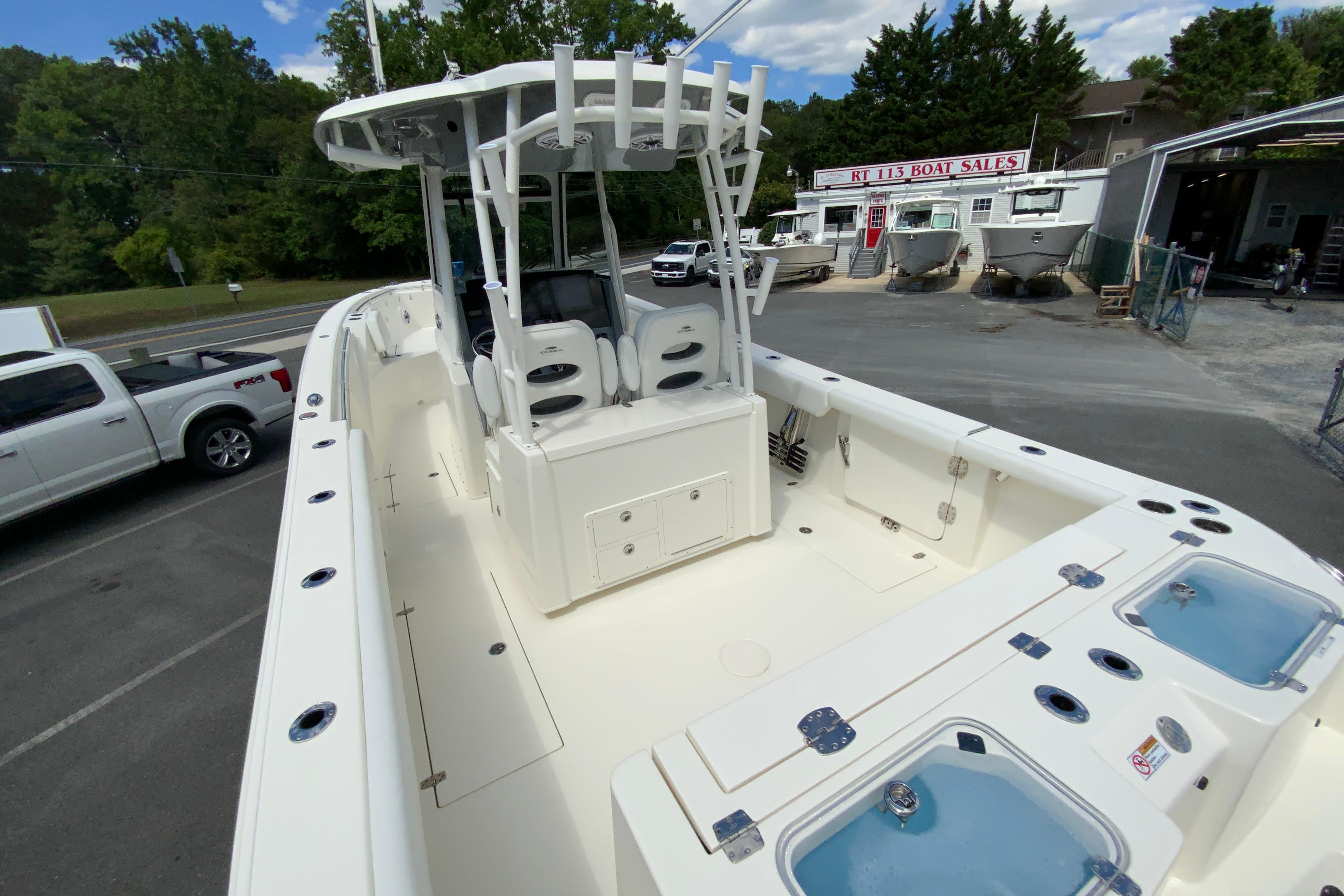 2027 Cobia 320 Center Console boat at dealership, featuring spacious deck and modern amenities.