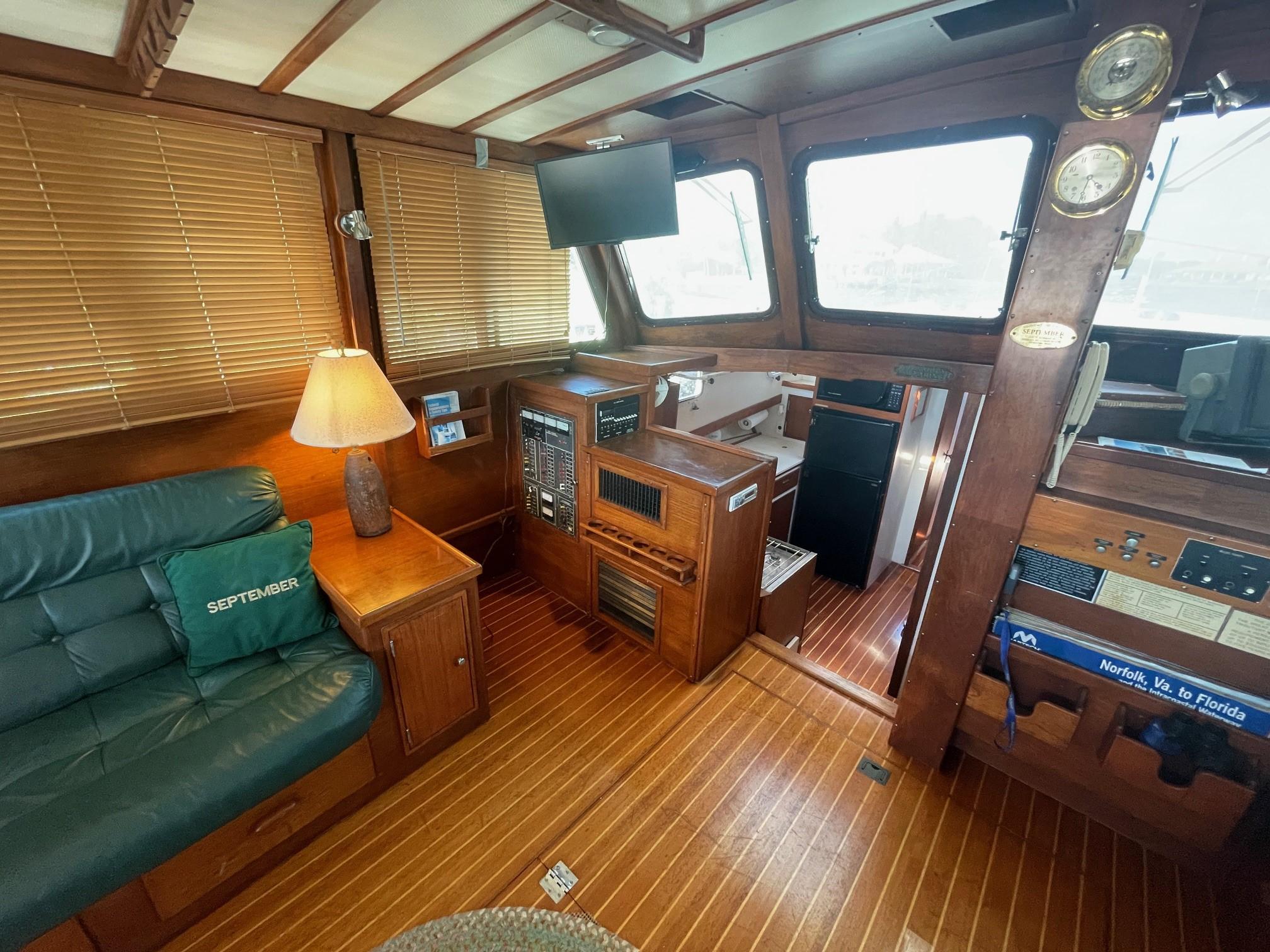 1979 Jarvis Newman Trawler interior with wooden finishes, leather seating, and navigation equipment.