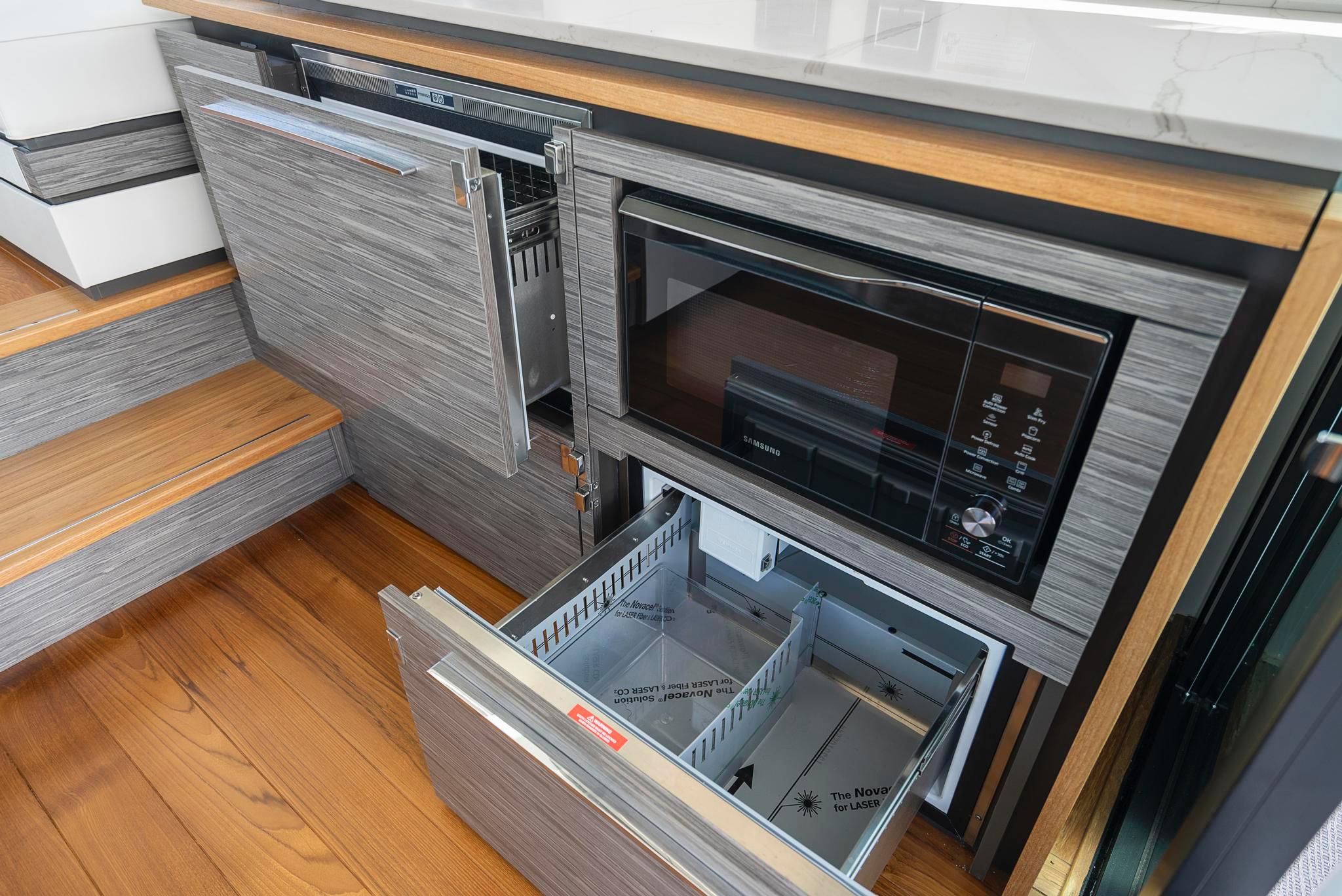 Modern kitchen appliances in 2022 Tiara Yachts C49 Coupe, featuring sleek cabinetry and wood flooring.