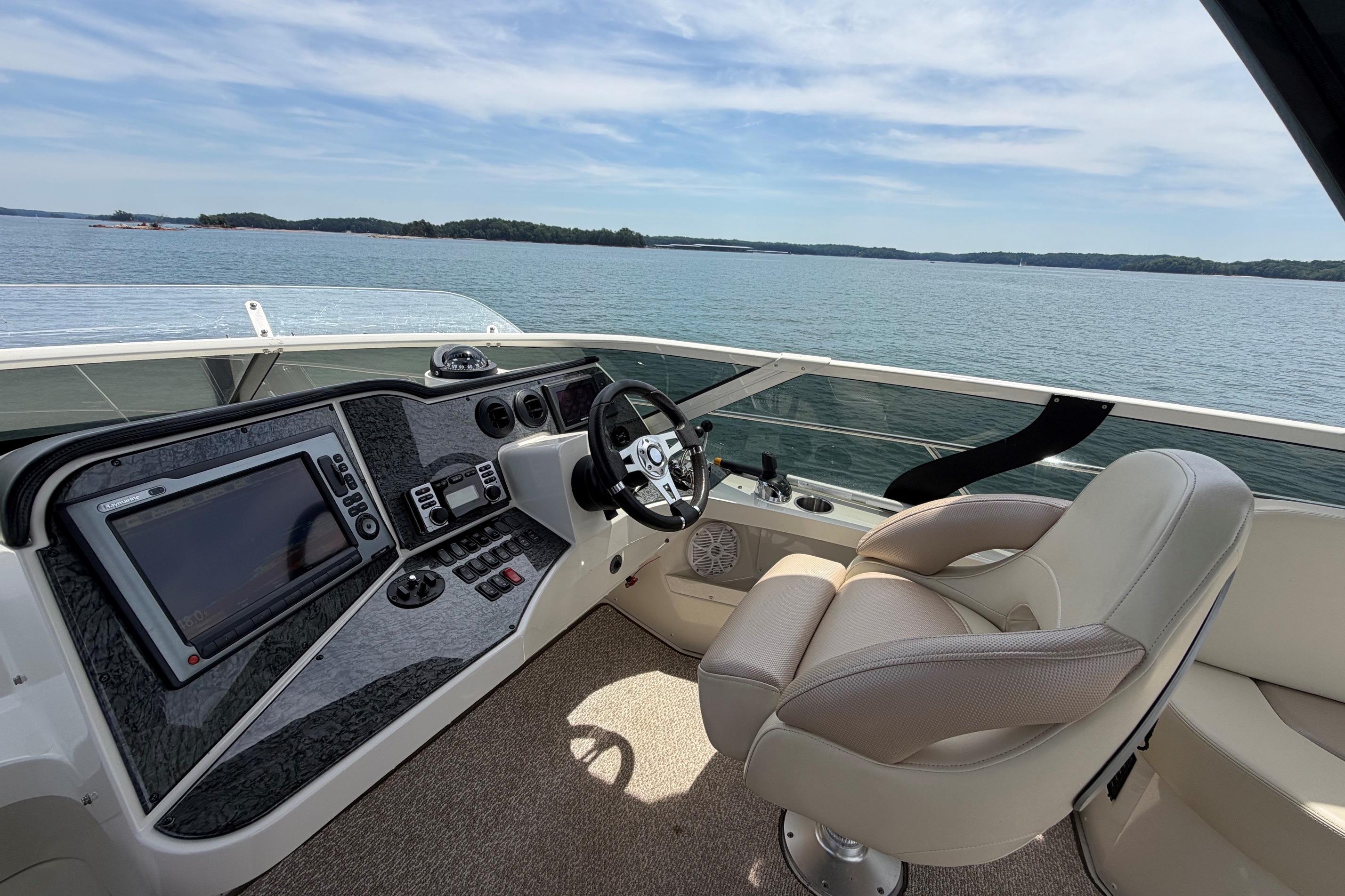 Helm of 2011 Carver 44 Sojourn yacht with modern controls and scenic water view.