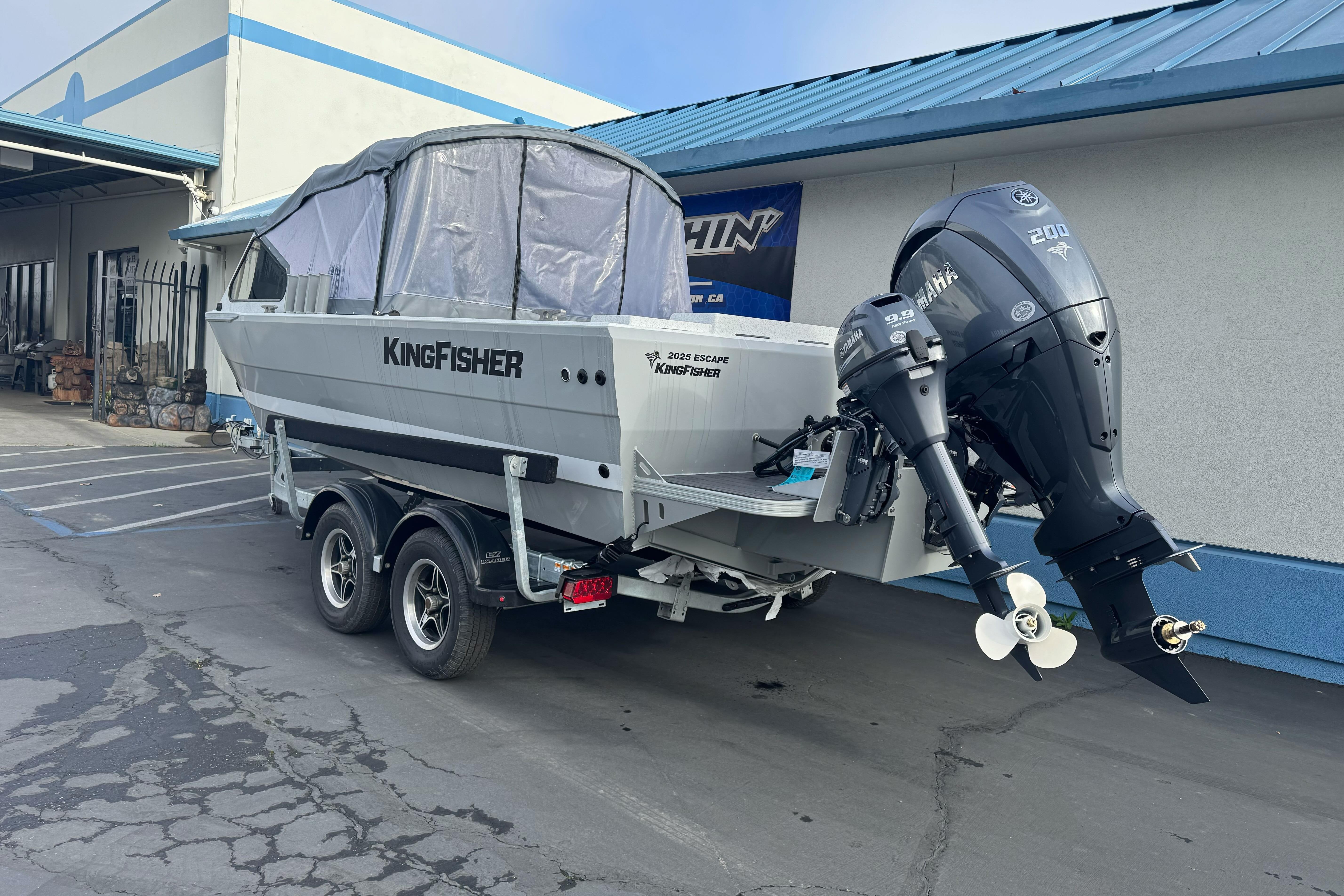 2026 KingFisher 2025 Escape boat on trailer, parked outside a building.
