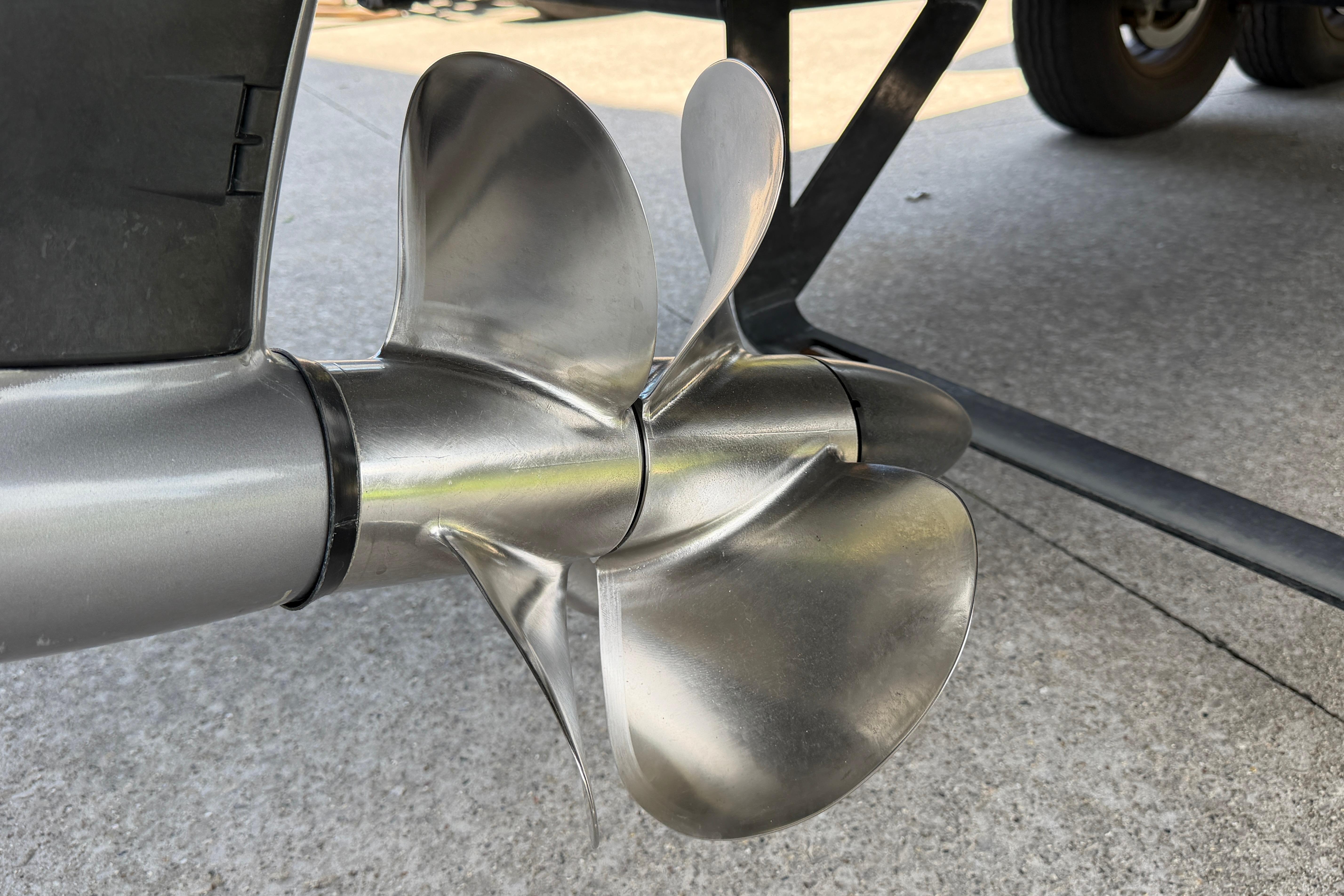 Close-up of a 2021 Cobalt R8 Surf boat propeller on a concrete surface.