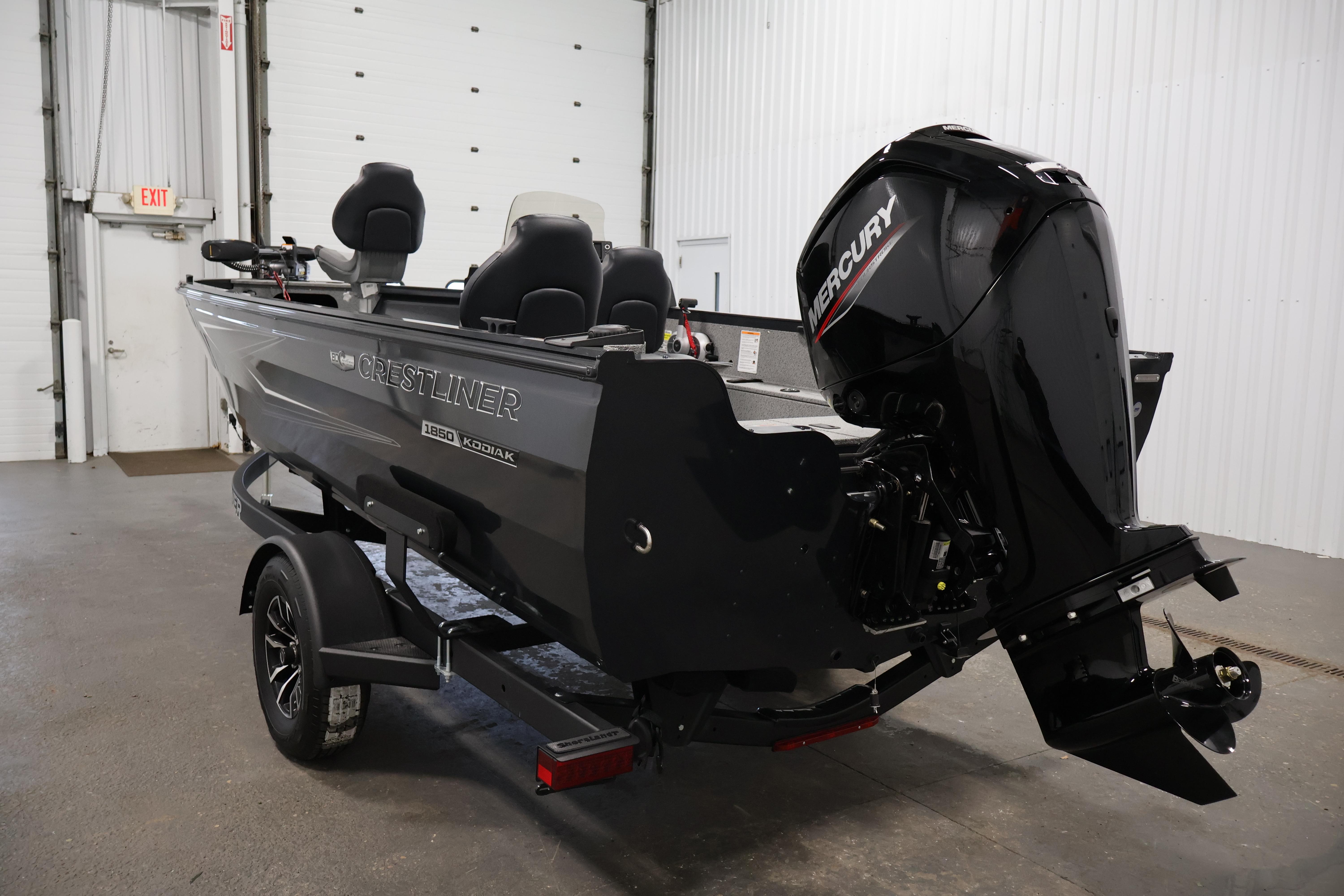 2026 Crestliner 1850 Kodiak SC boat with Mercury outboard motor in a garage.
