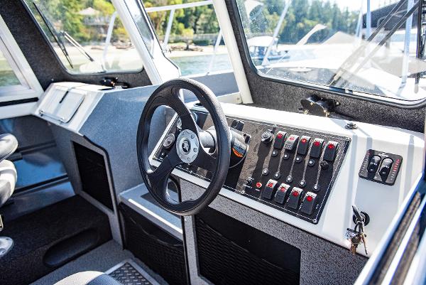 2023 Spartan 220 Maximus Pro boat cockpit with steering wheel and control panel.