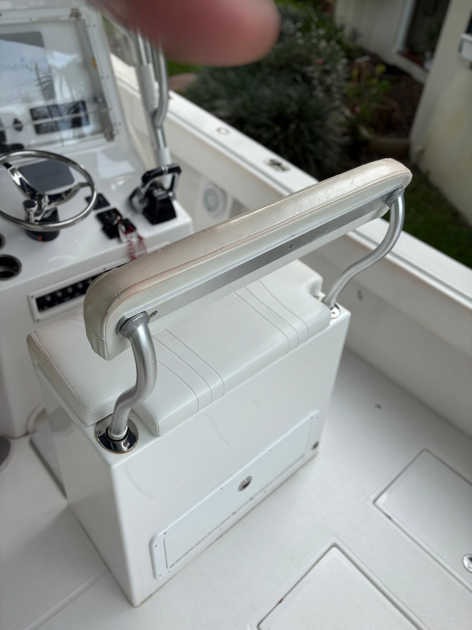 White boat seat with metal handles and control console in the background.