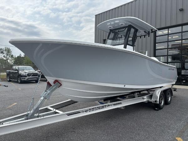 2025 Sportsman Open 232 boat on trailer, parked outside a building.
