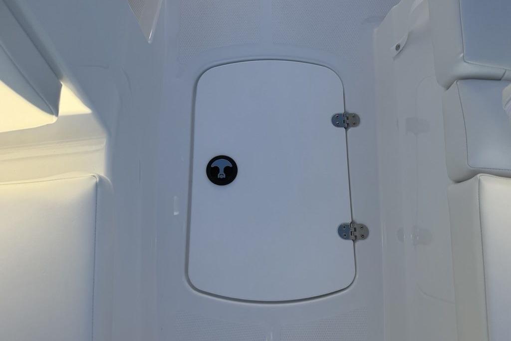 2026 Tahoe T16 boat storage compartment with white interior and secure latch.