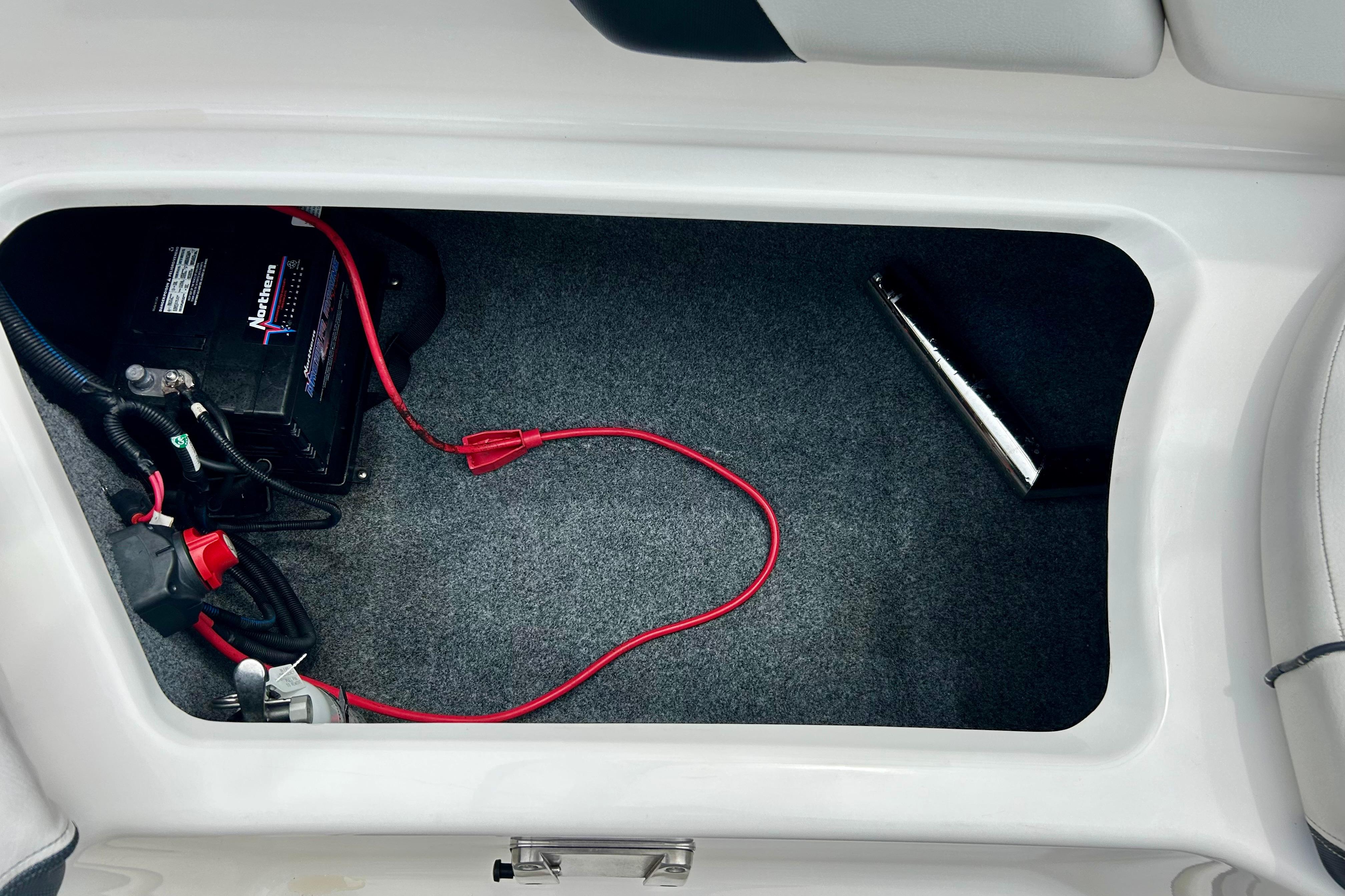 2015 Yamaha AR210 boat battery compartment with wiring and carpeted interior.