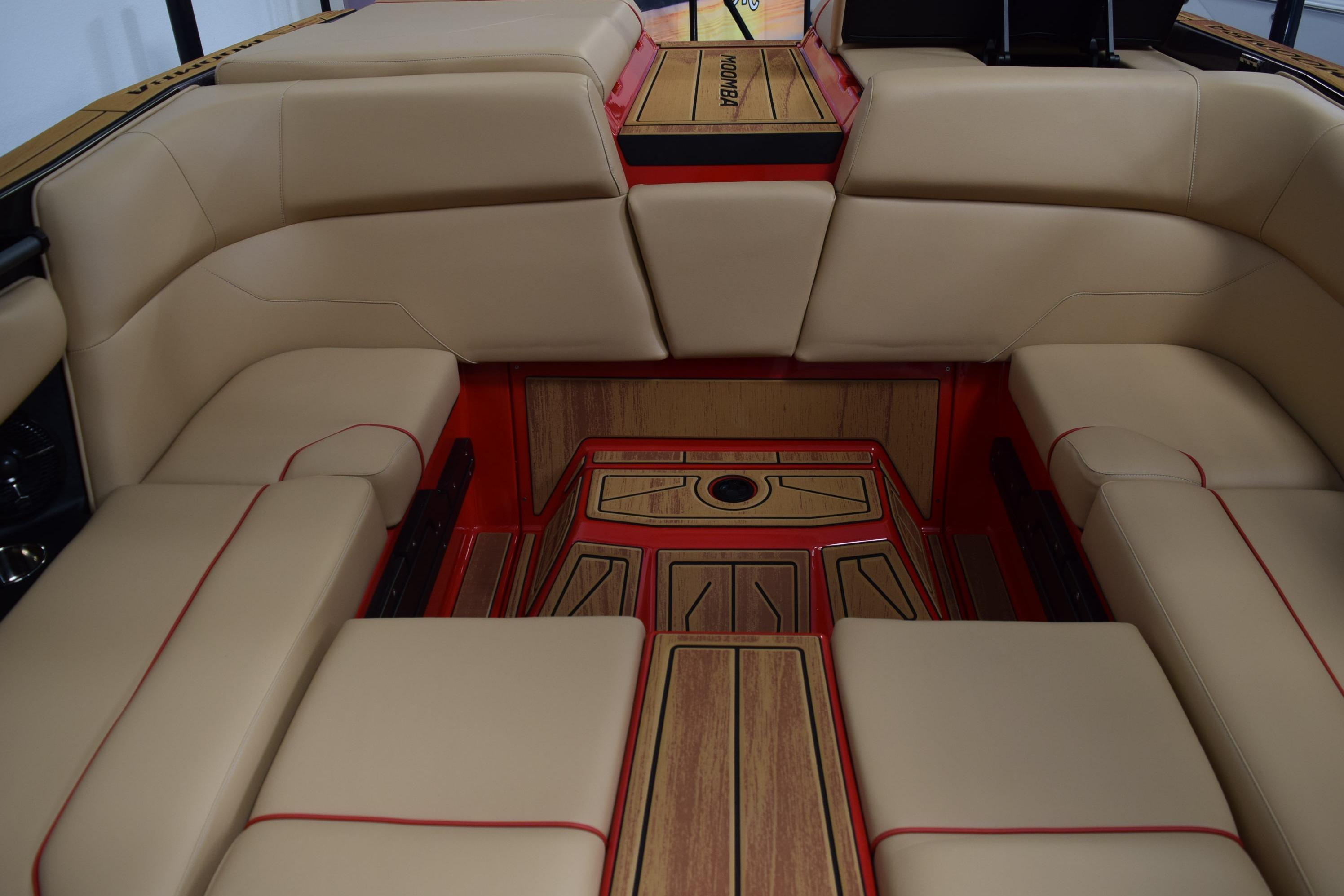 2026 Moomba Max boat interior with beige seating and red accents.