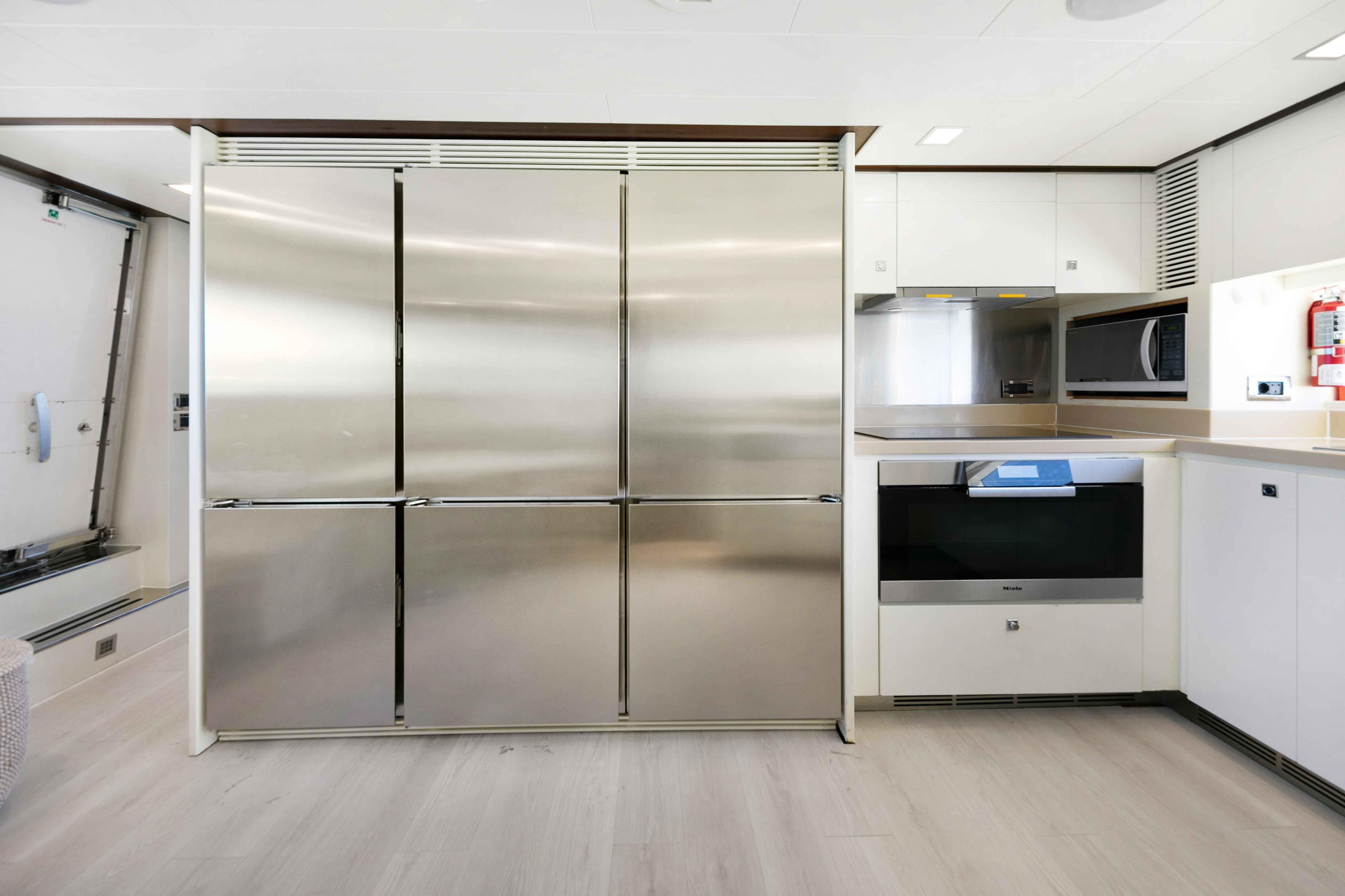 Modern kitchen interior on 2012 Azimut Grande 32M yacht, featuring stainless steel appliances.