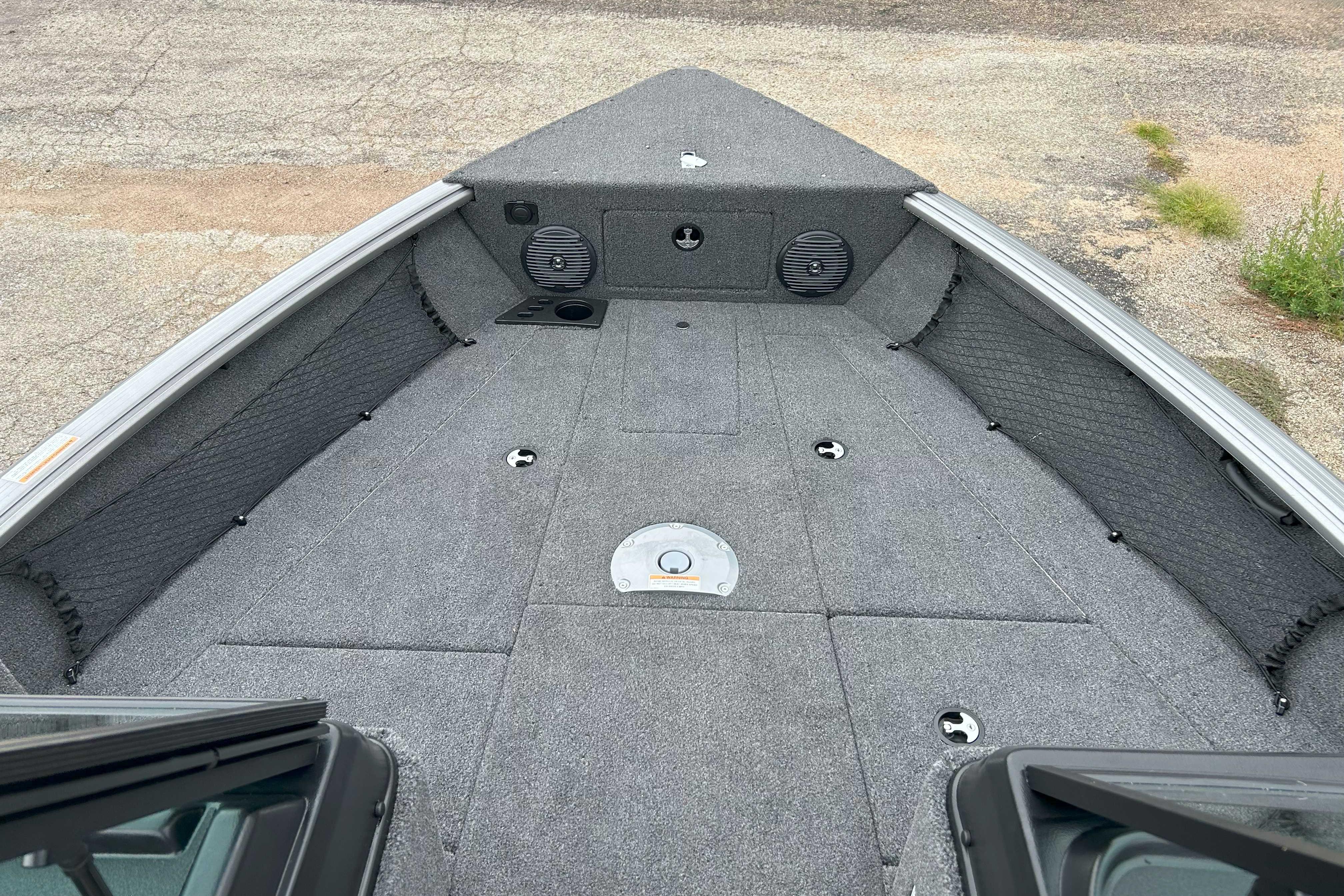 2026 Lund 1875 Impact XS Sport boat interior with carpeted deck and storage compartments.