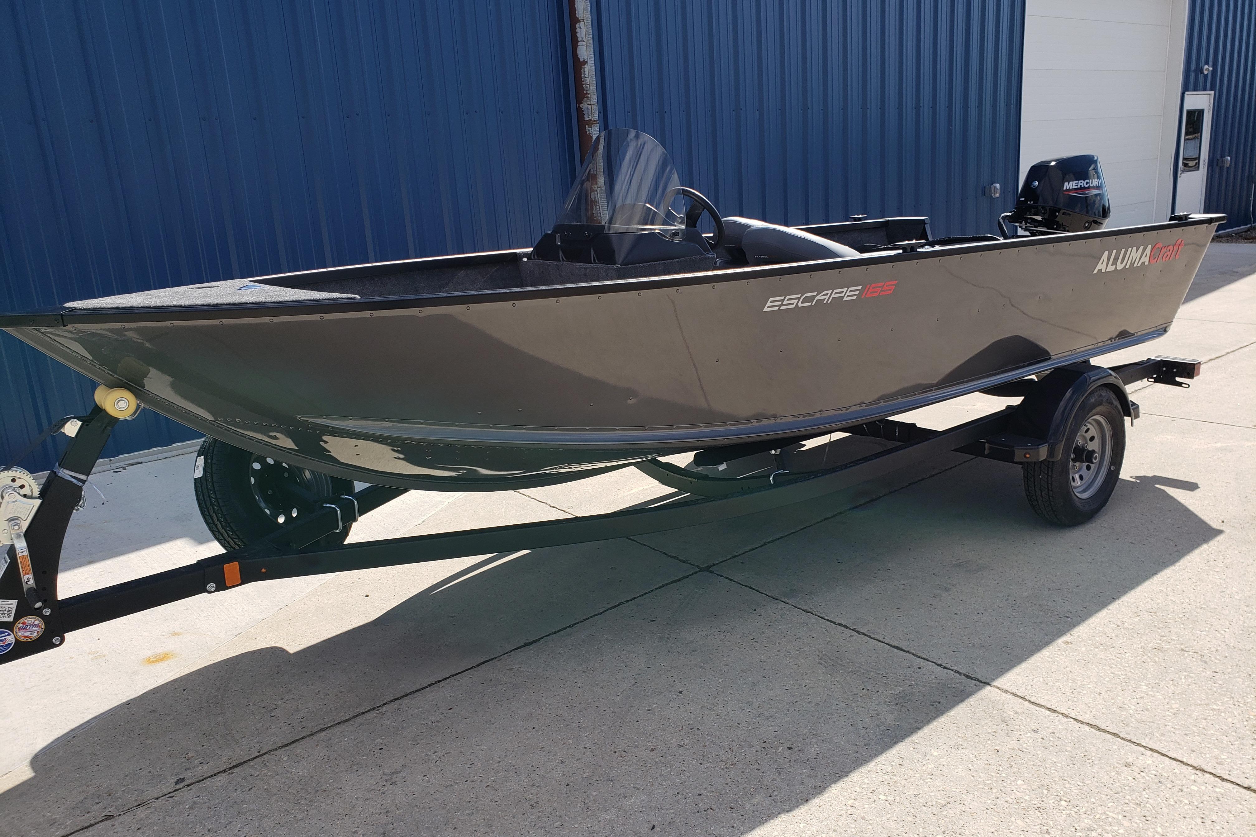 2026 Alumacraft Escape 165 CS boat on trailer, parked outdoors.