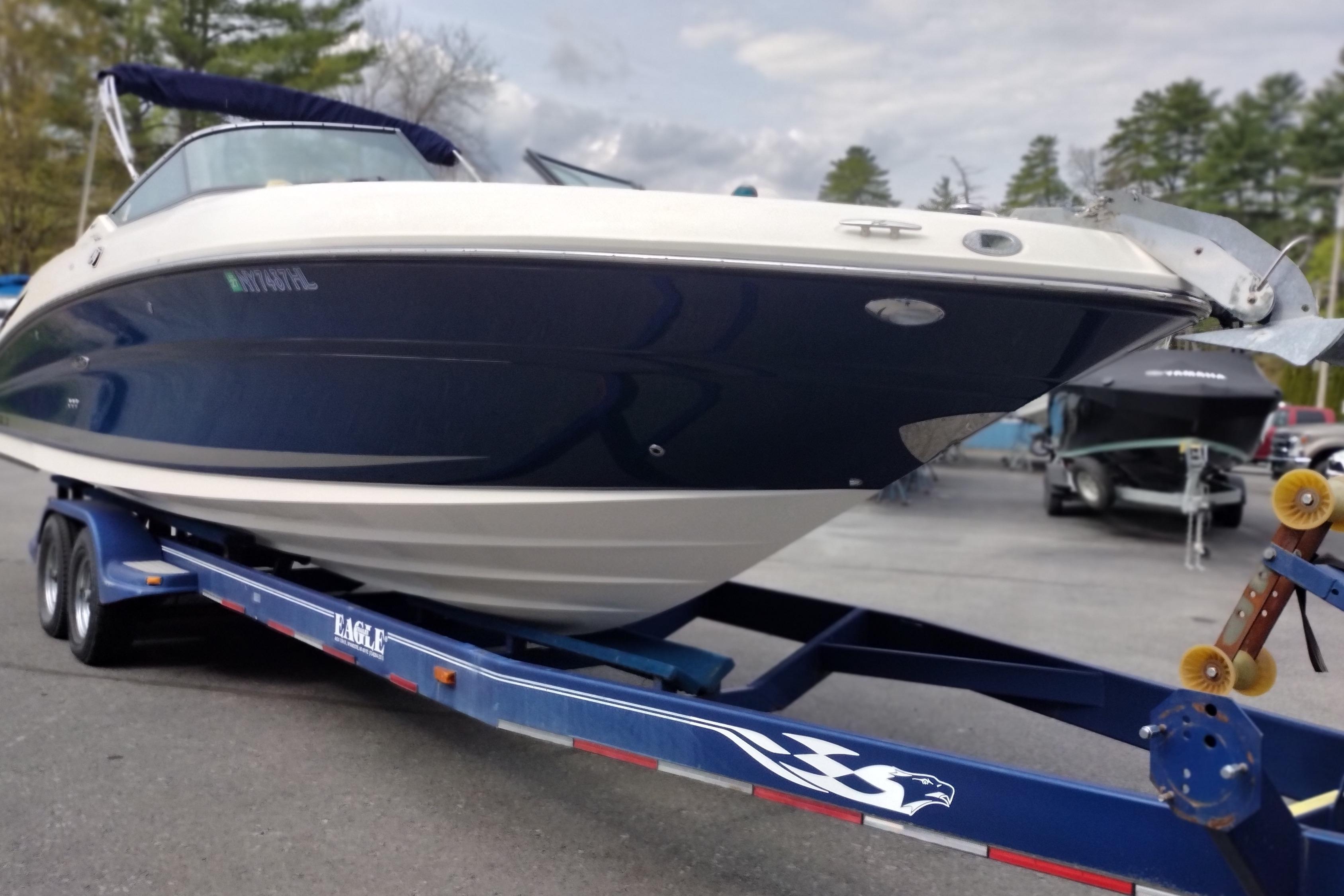 2013 Sea Ray 300 SLX boat on a trailer, parked outdoors with trees in the background.