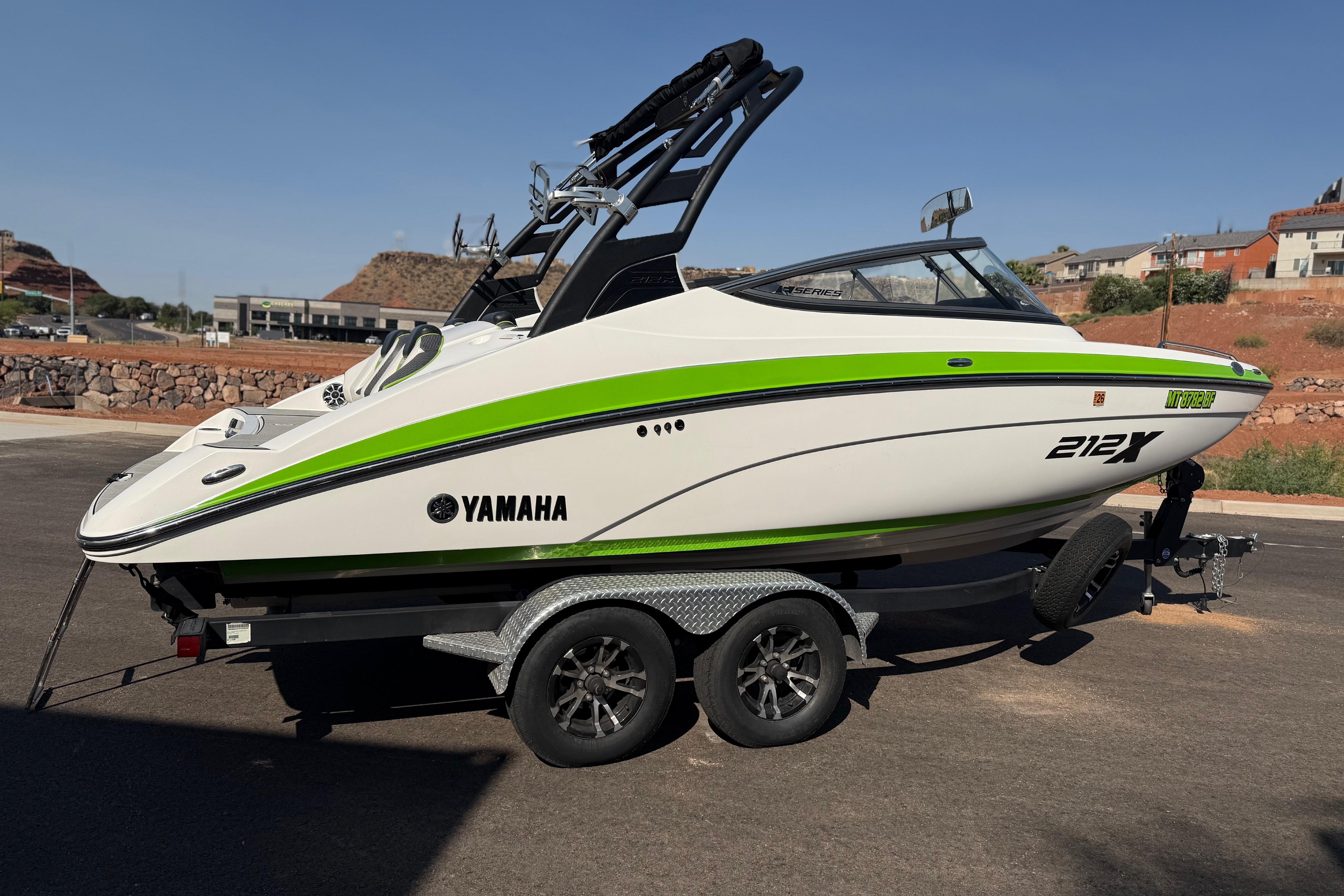 2022 Yamaha Boats 212XE on trailer, featuring sleek design with green accents.