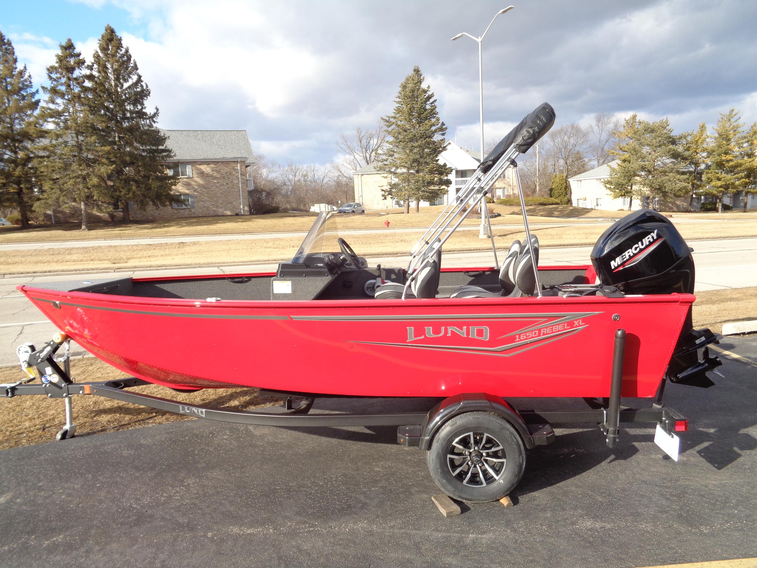 2025 Lund 1650 Rebel XL SS boat, red, on trailer, parked outdoors.
