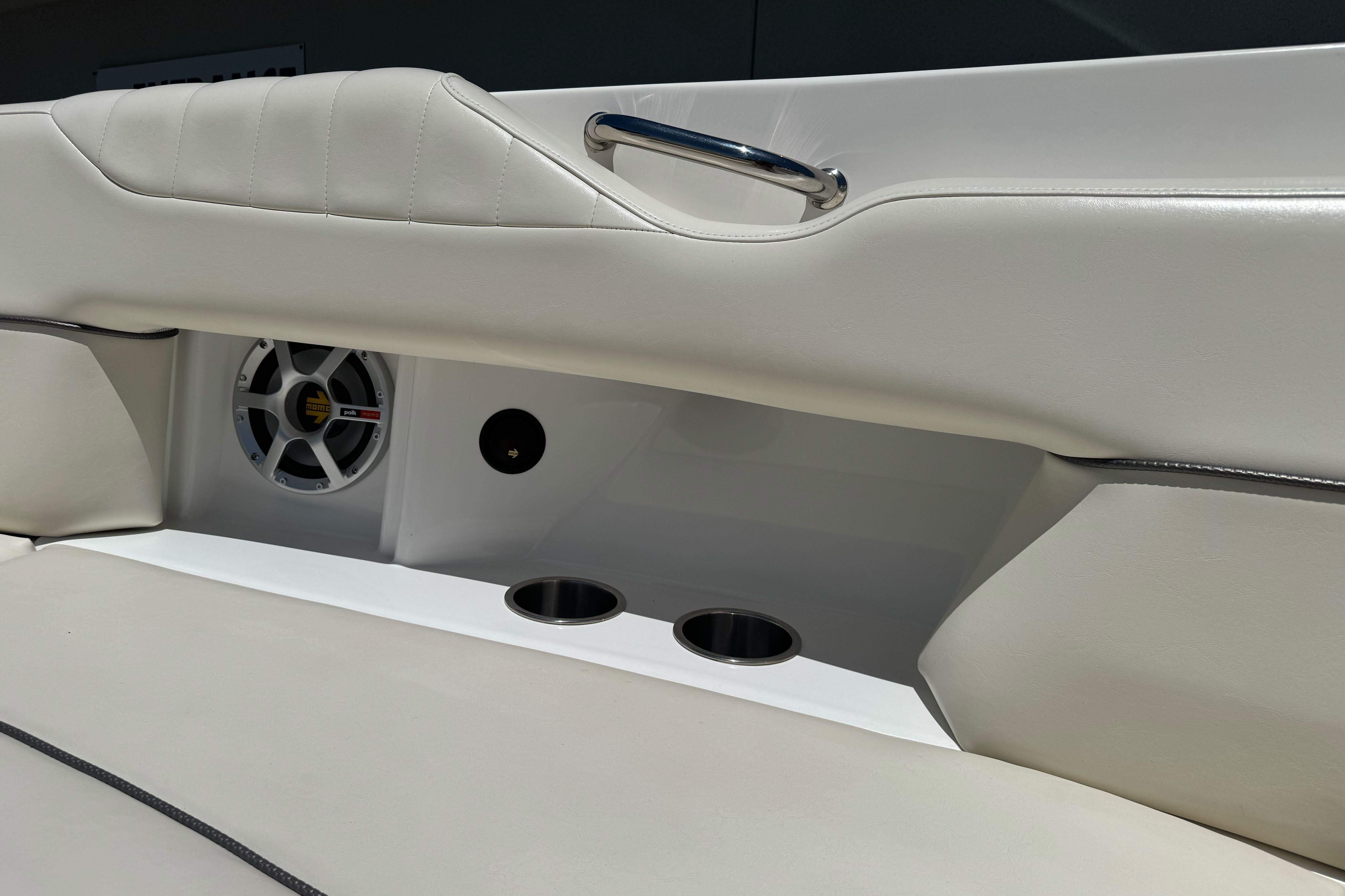 Interior of 2007 Sea Ray SLX 250 boat with white seating and speaker system.