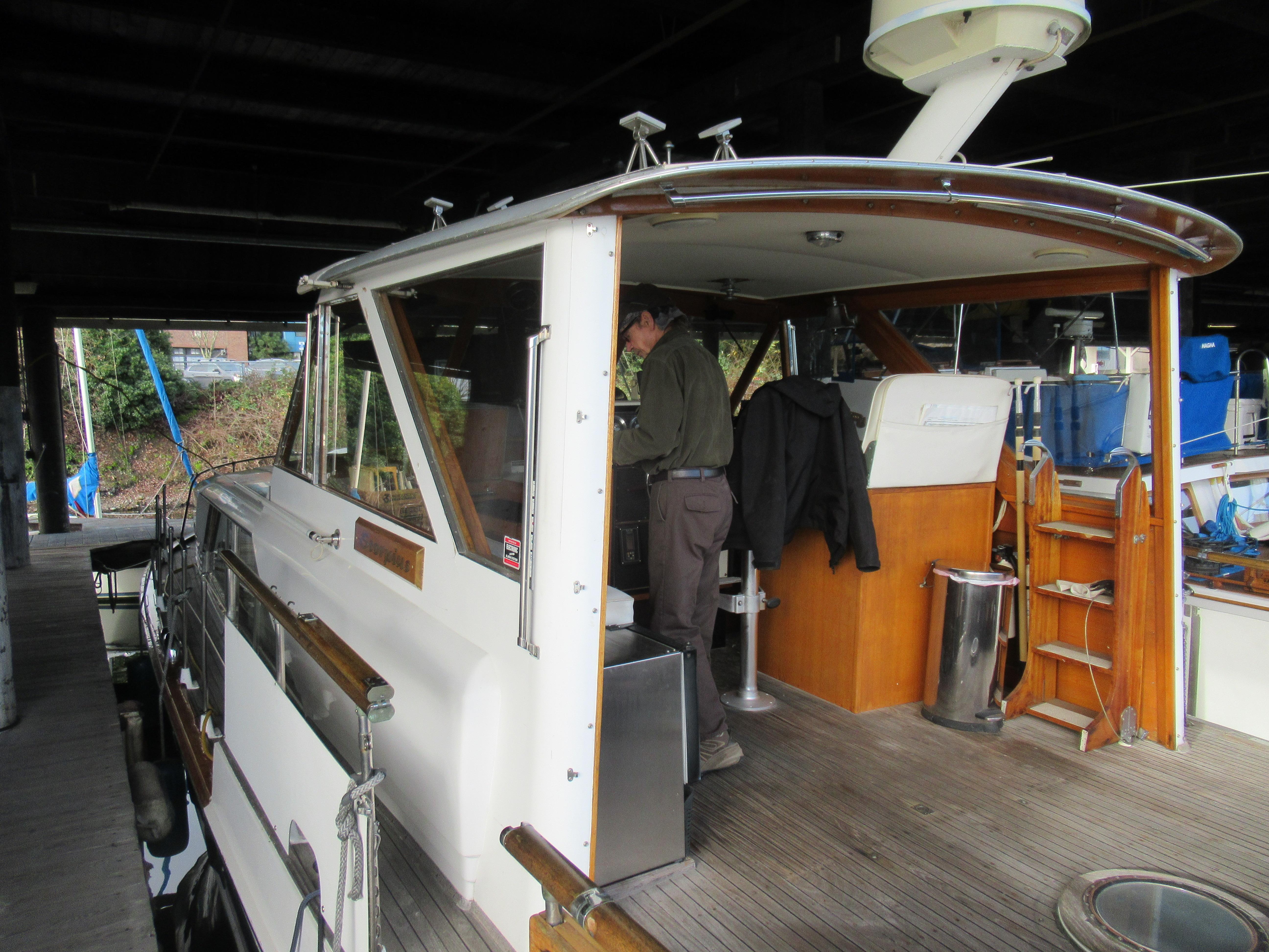 1963 Chris-Craft Constellation boat docked, featuring wooden deck and cabin interior.