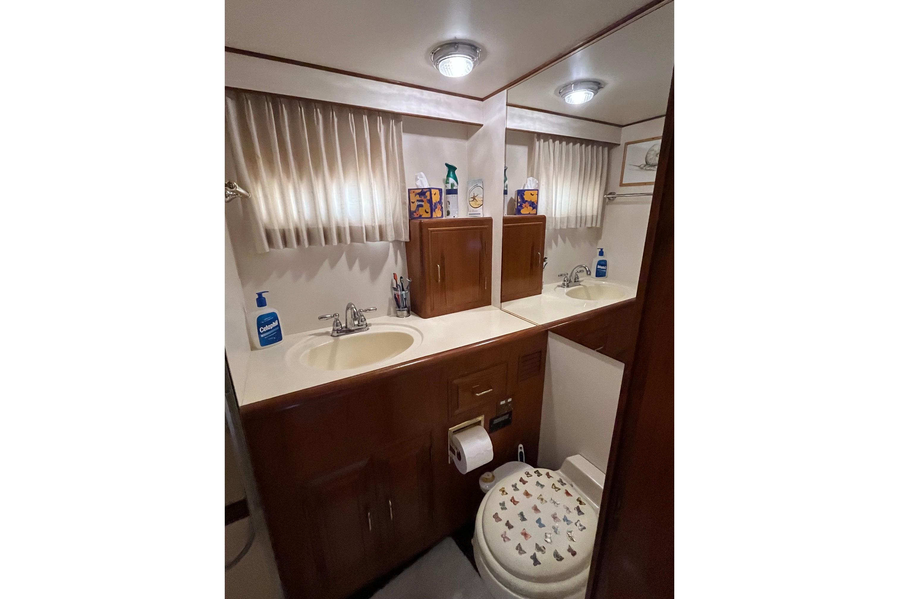 Bathroom interior of 1989 Ocean Alexander 440 Sundeck CPMY yacht, featuring sink and toilet.