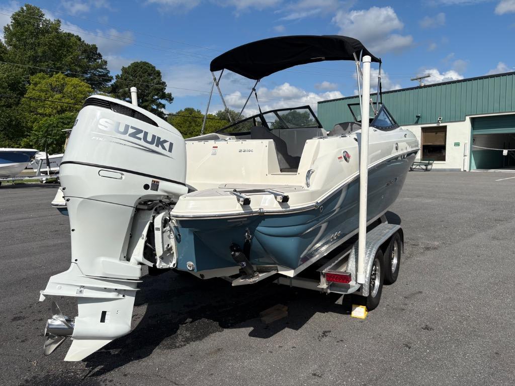 2021 Stingray 231 DC boat with Suzuki outboard motor on a trailer, parked outdoors.
