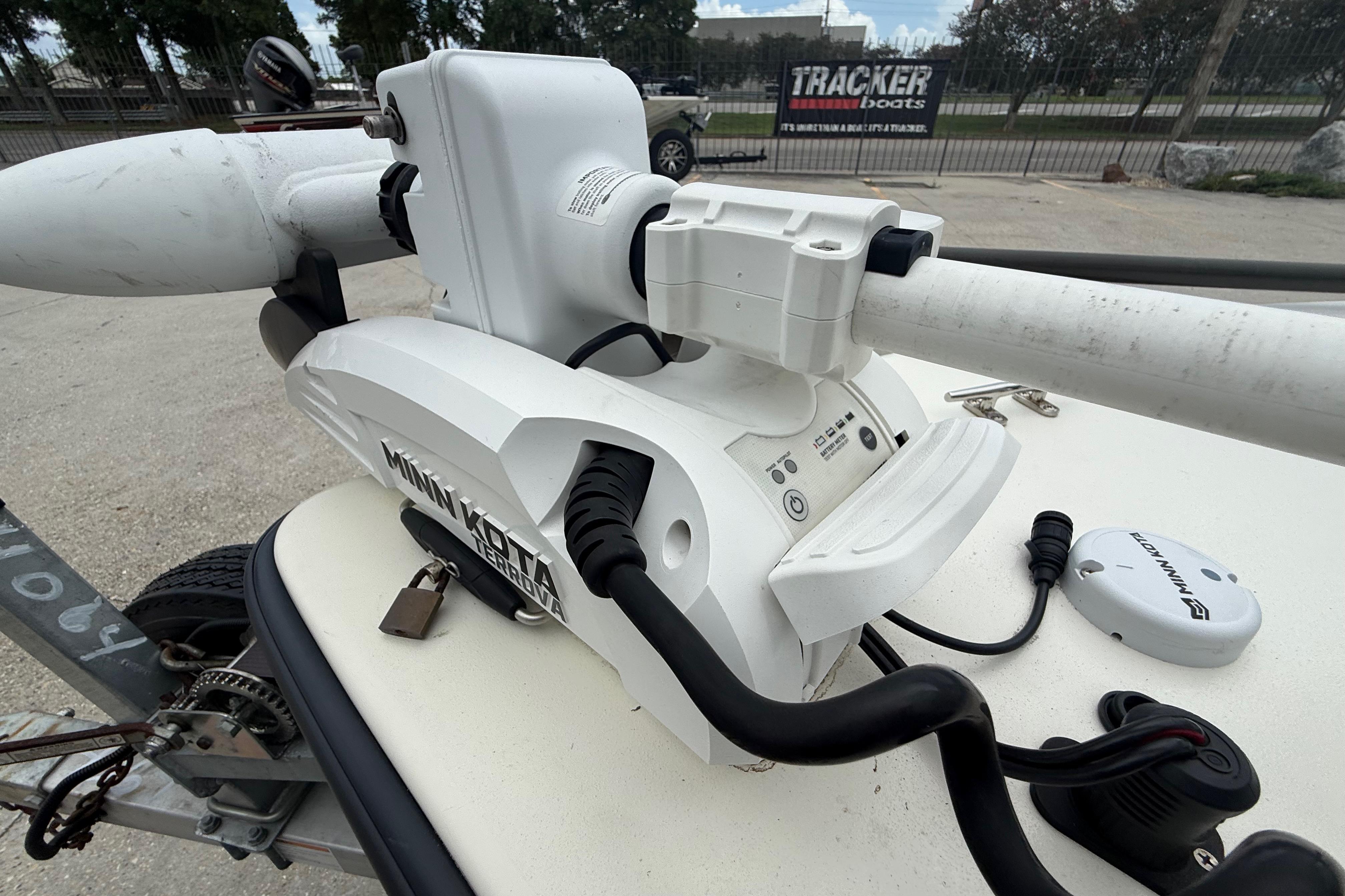Minn Kota trolling motor on 2020 Skimmer Skiff 14 boat, parked near Tracker Boats sign.