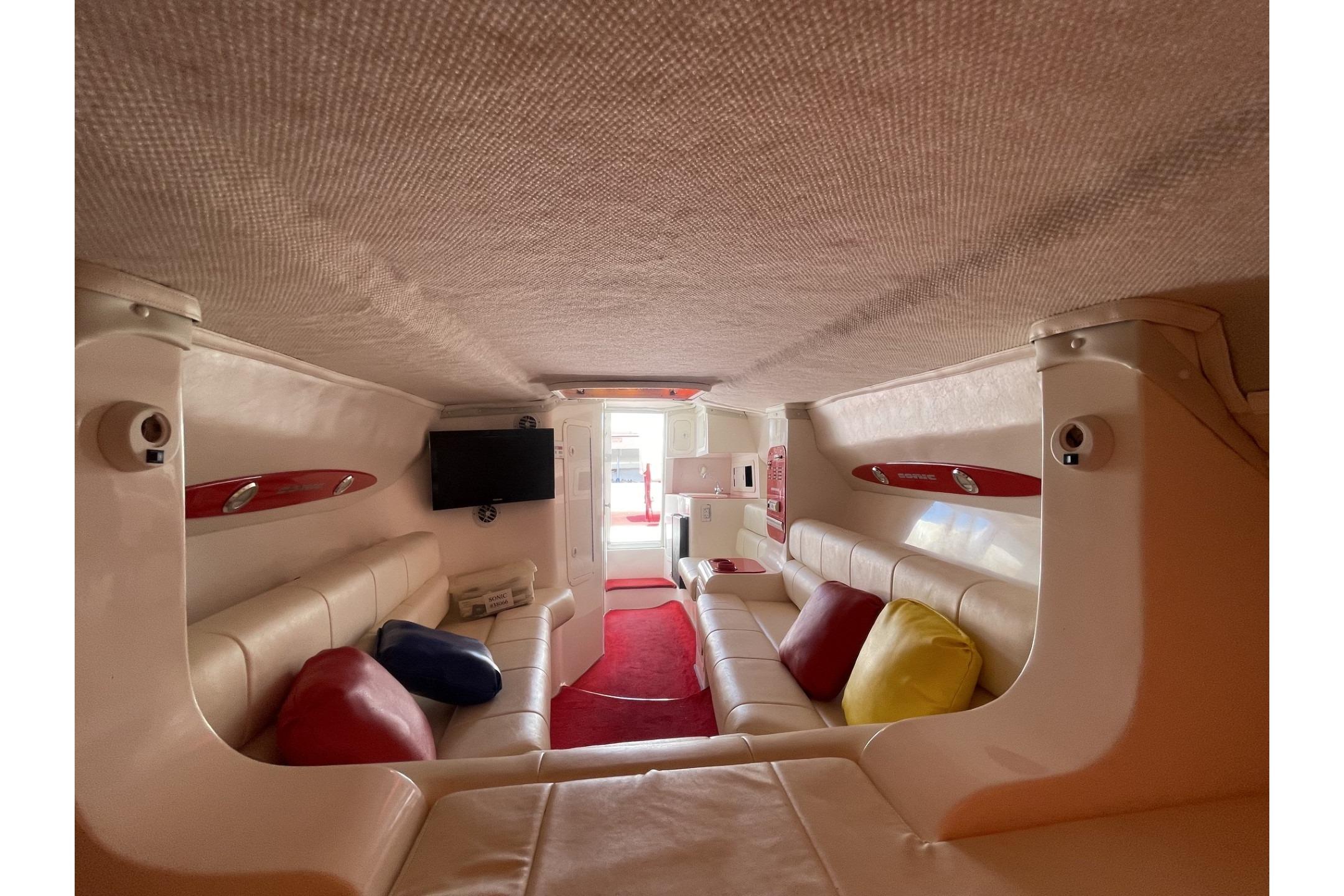 Luxurious interior of a 2006 Sonic 386 boat with plush seating and vibrant cushions.