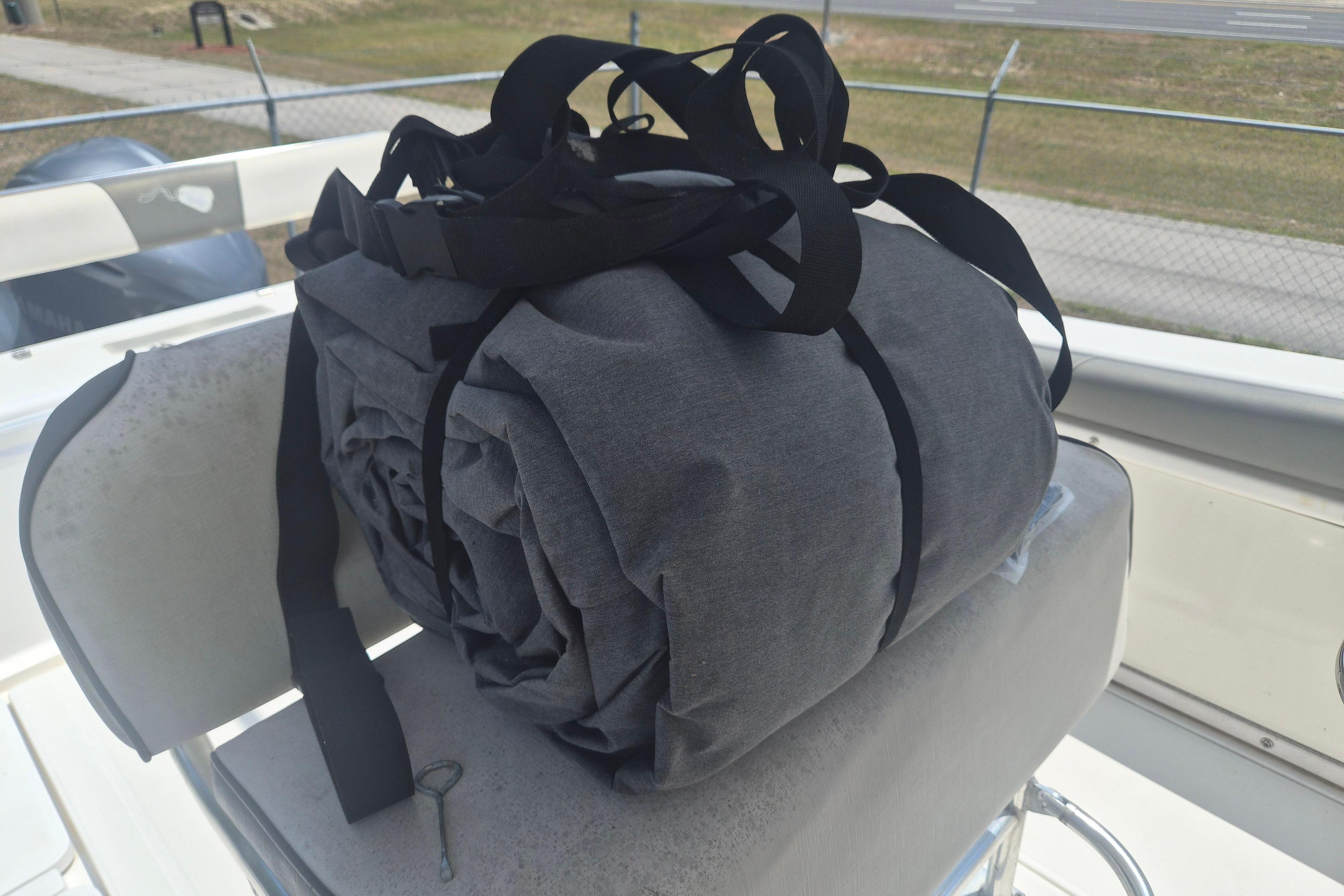 Rolled-up boat cover on 2006 Century 2900 Center Console, secured with black straps.
