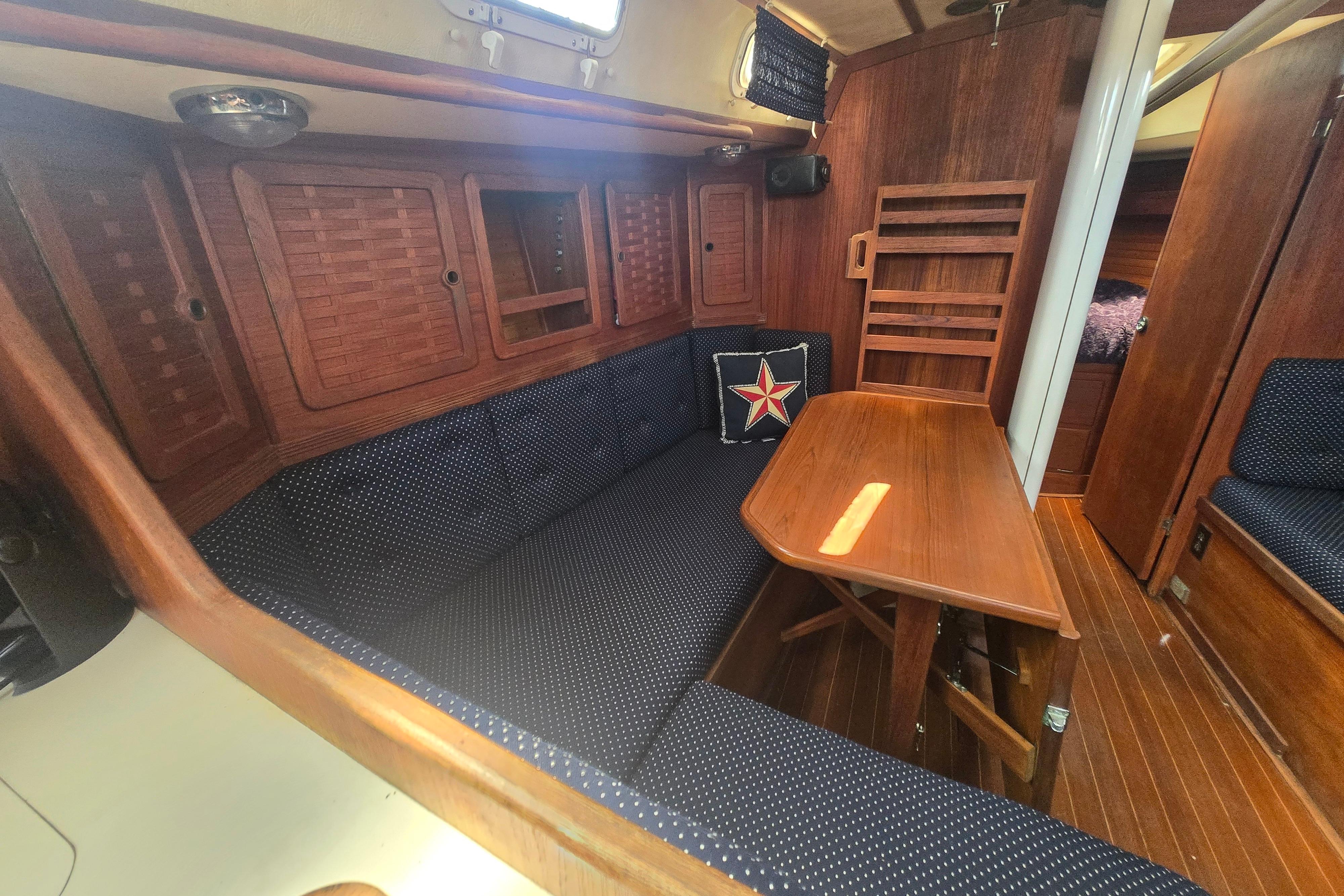 Interior of 1988 Sabre 38 sailboat with wooden table and navy seating.