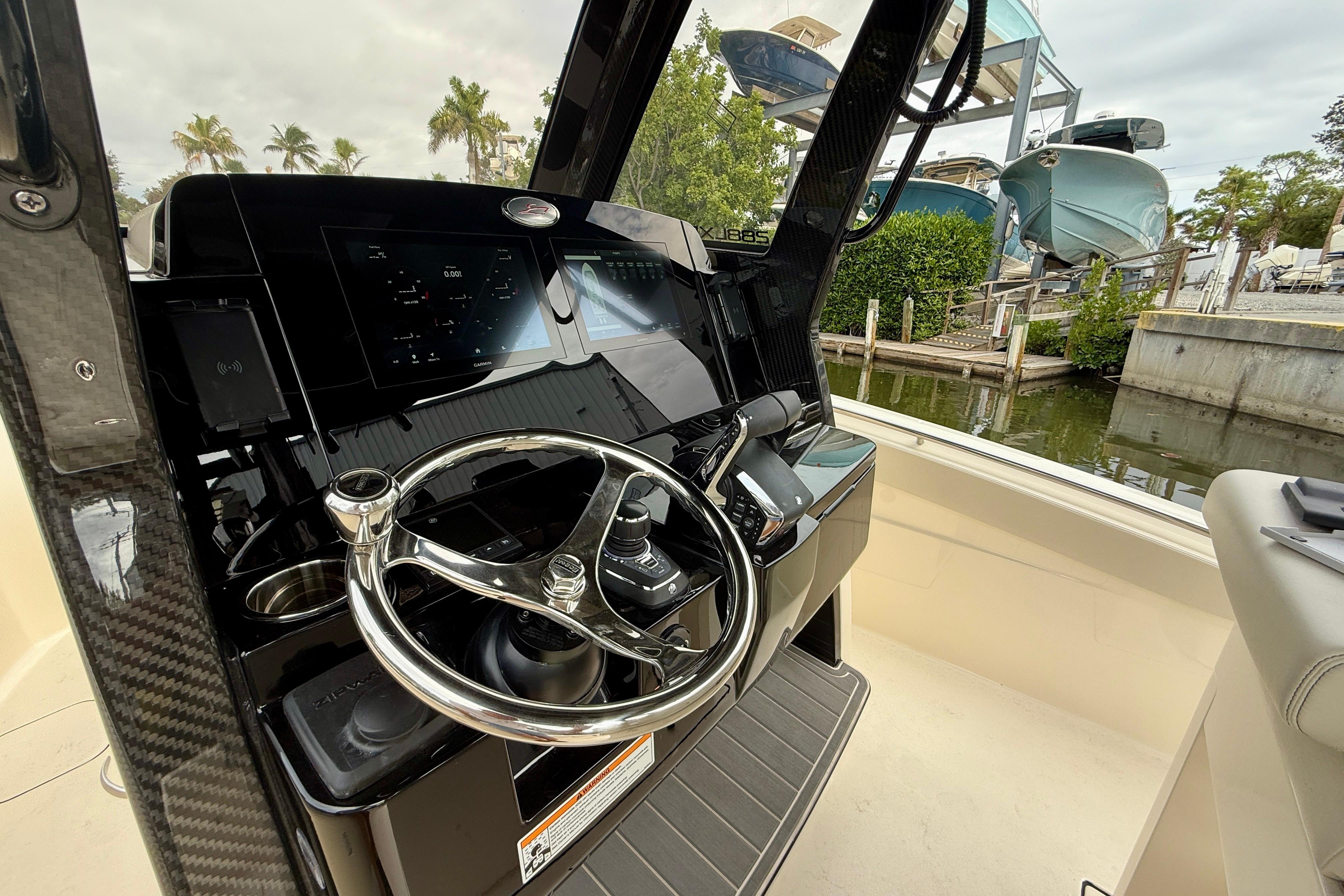 2026 Scout 288 LXF boat helm with modern controls and steering wheel, dockside view.