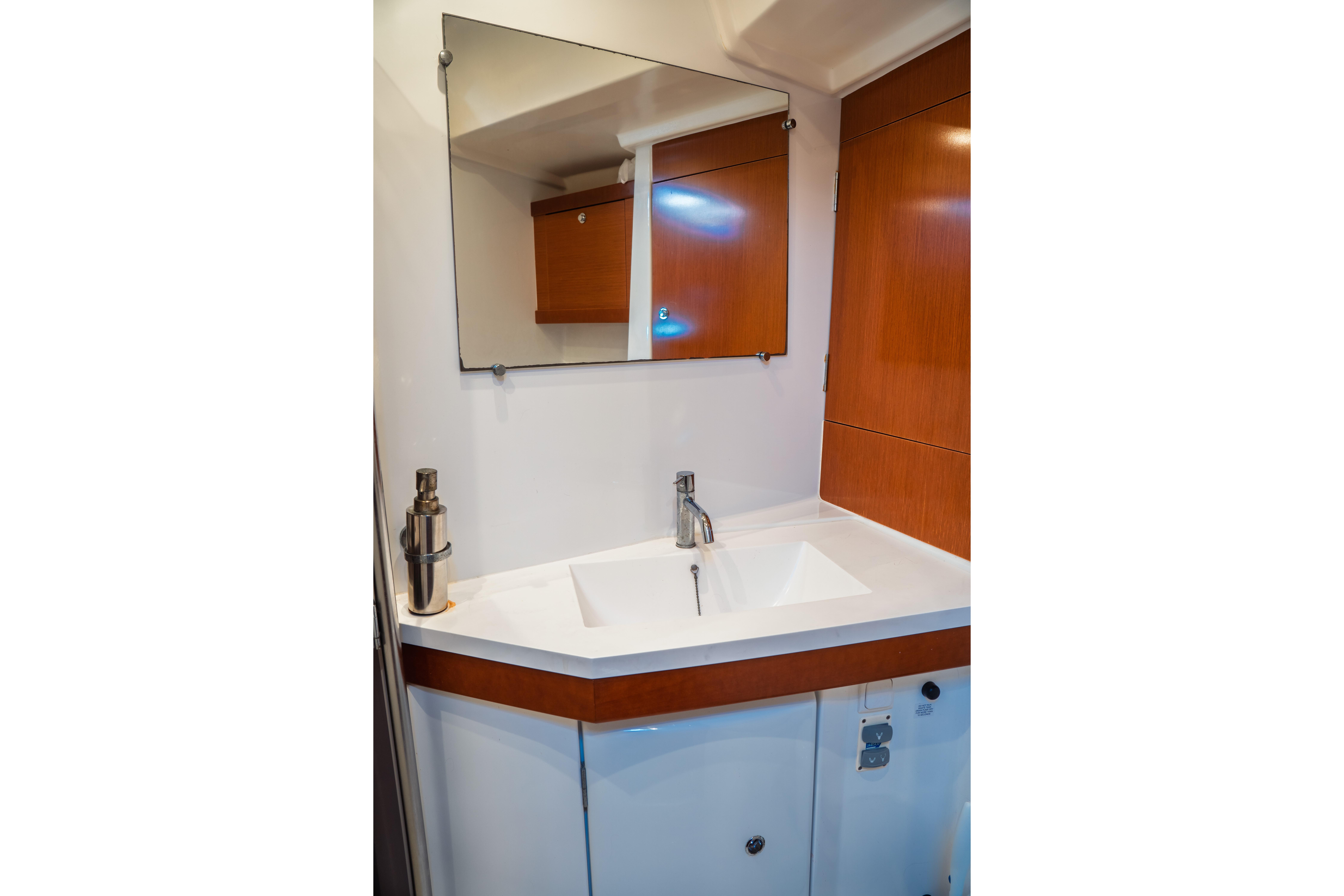 Bathroom vanity in 2011 Beneteau Oceanis 50 yacht with mirror and modern sink.