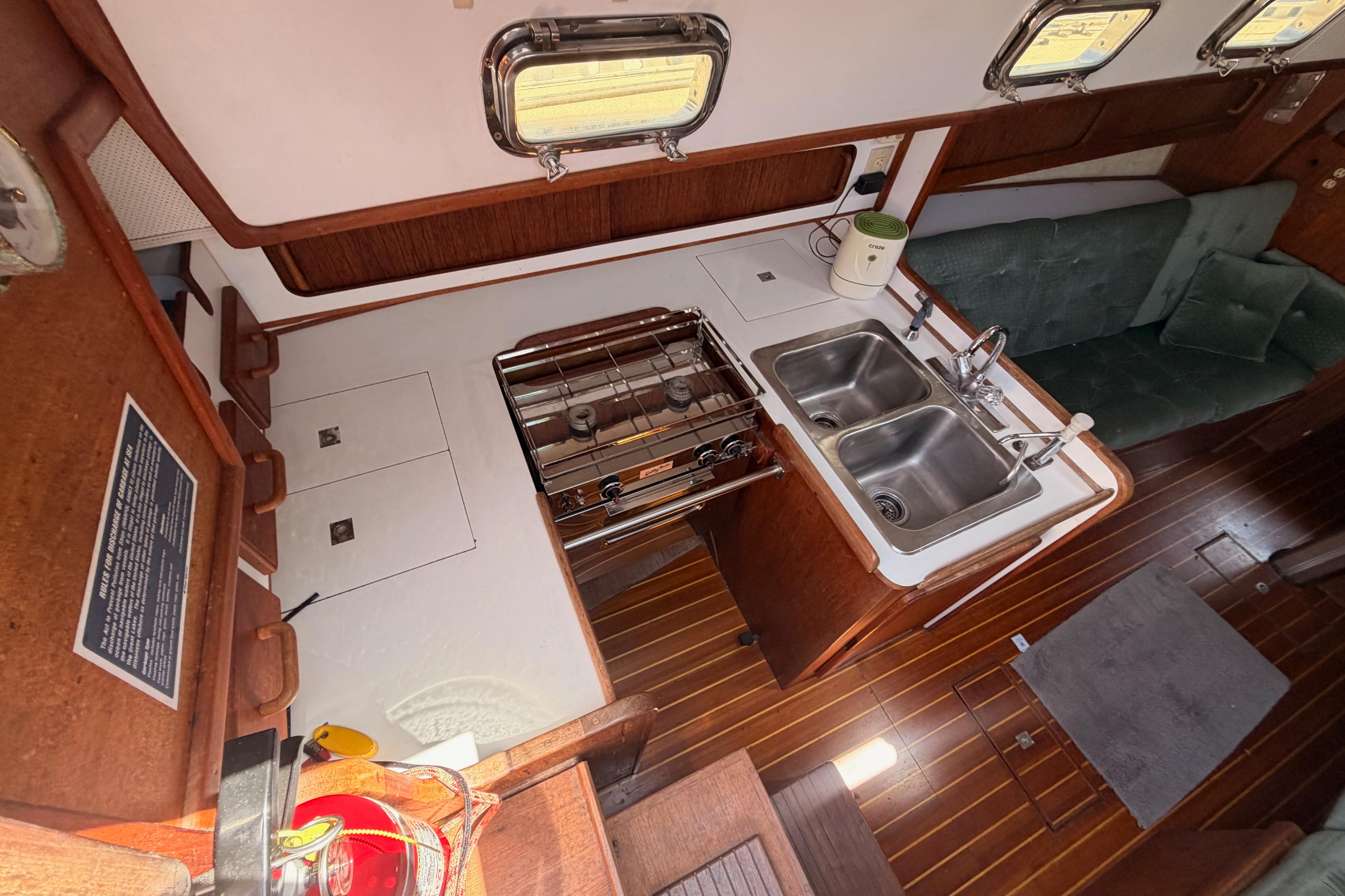 Interior of a 1991 Caliber 33 sailboat featuring a compact kitchen with dual sinks.