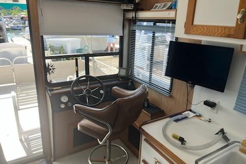 Interior of a 1994 PlayCraft 5215 boat with steering wheel and seating area.