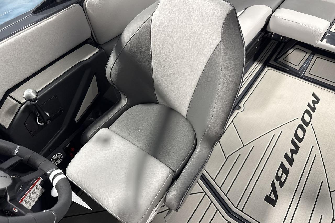 Interior of a Moomba Craz boat with gray seating and steering wheel.