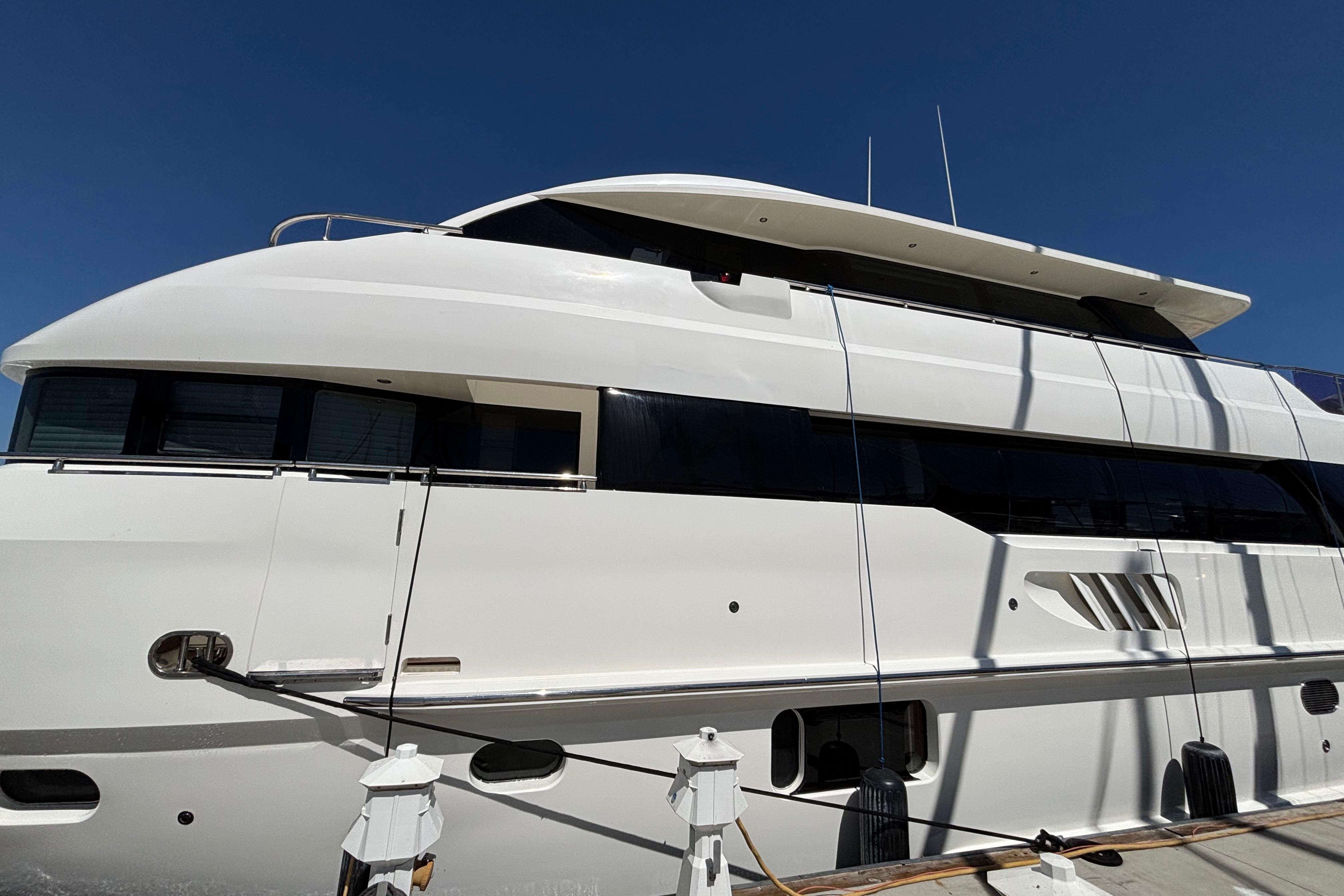 Luxury Norseman 80 yacht docked, 2010 model, sleek white design under clear blue sky.