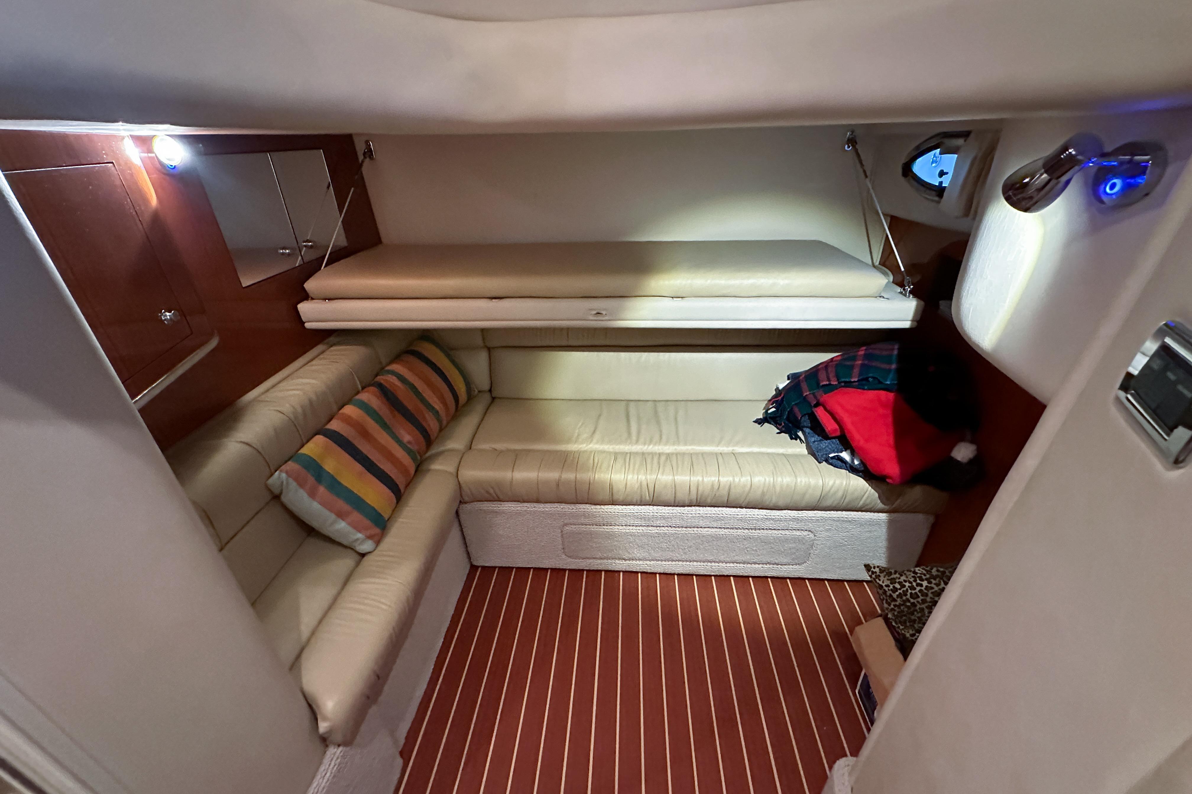 Interior cabin of 2001 Sea Ray 410 Sundancer with beige seating and striped cushions.