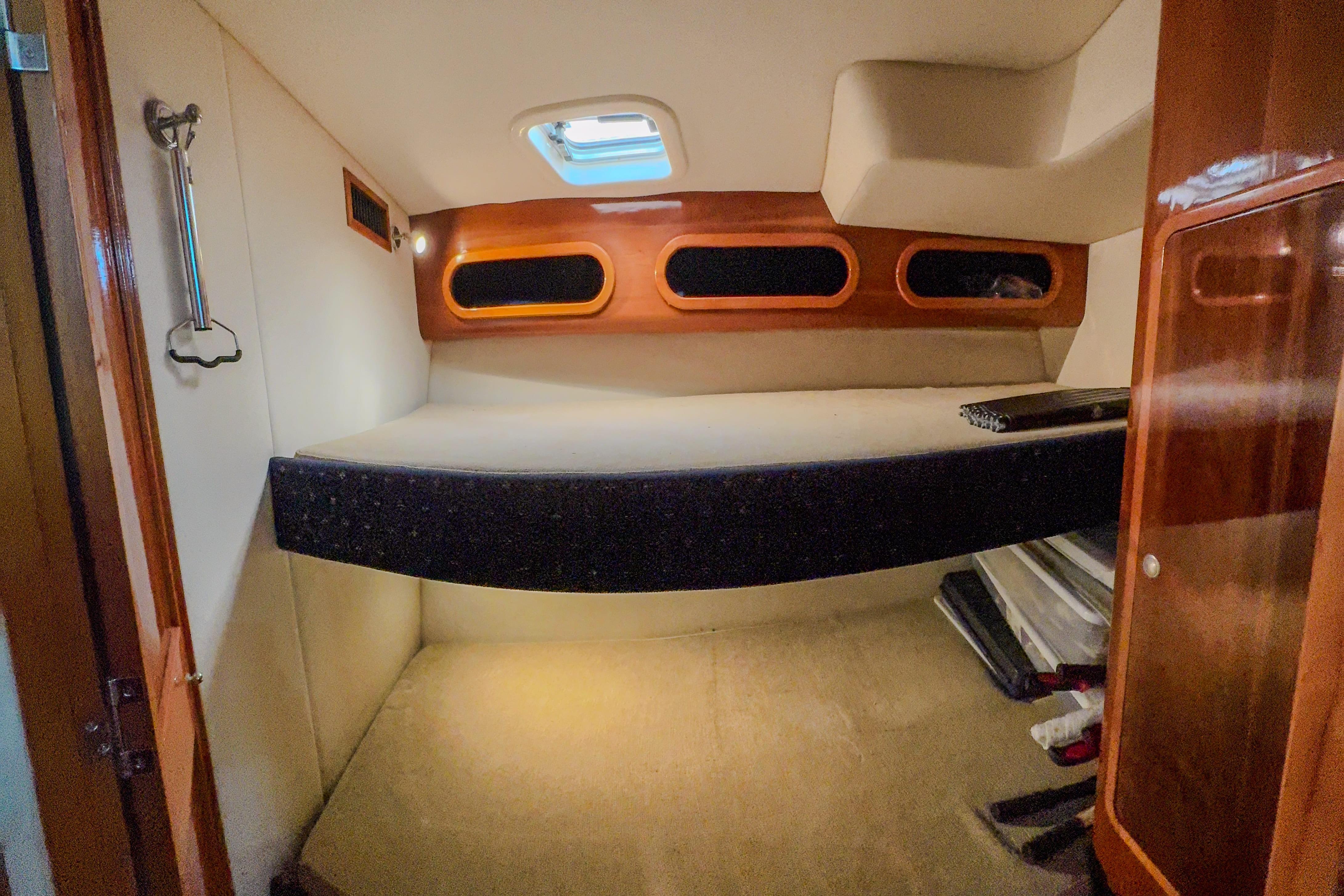 Cozy cabin interior of 2001 Black Watch 40 boat with wooden accents and porthole windows.