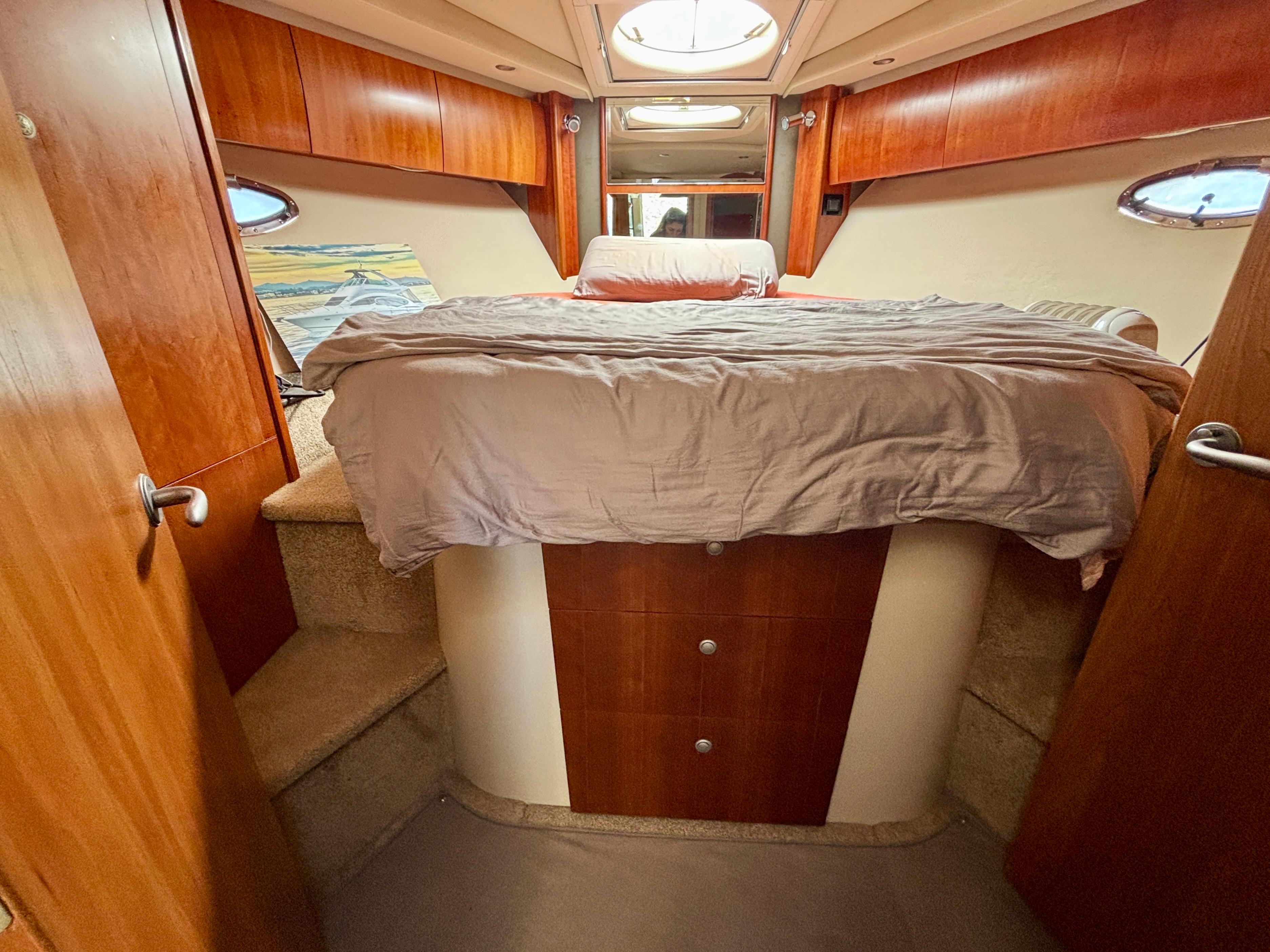 2007 Cruisers Yachts 447 Sport Sedan bedroom with wood accents and cozy bed.