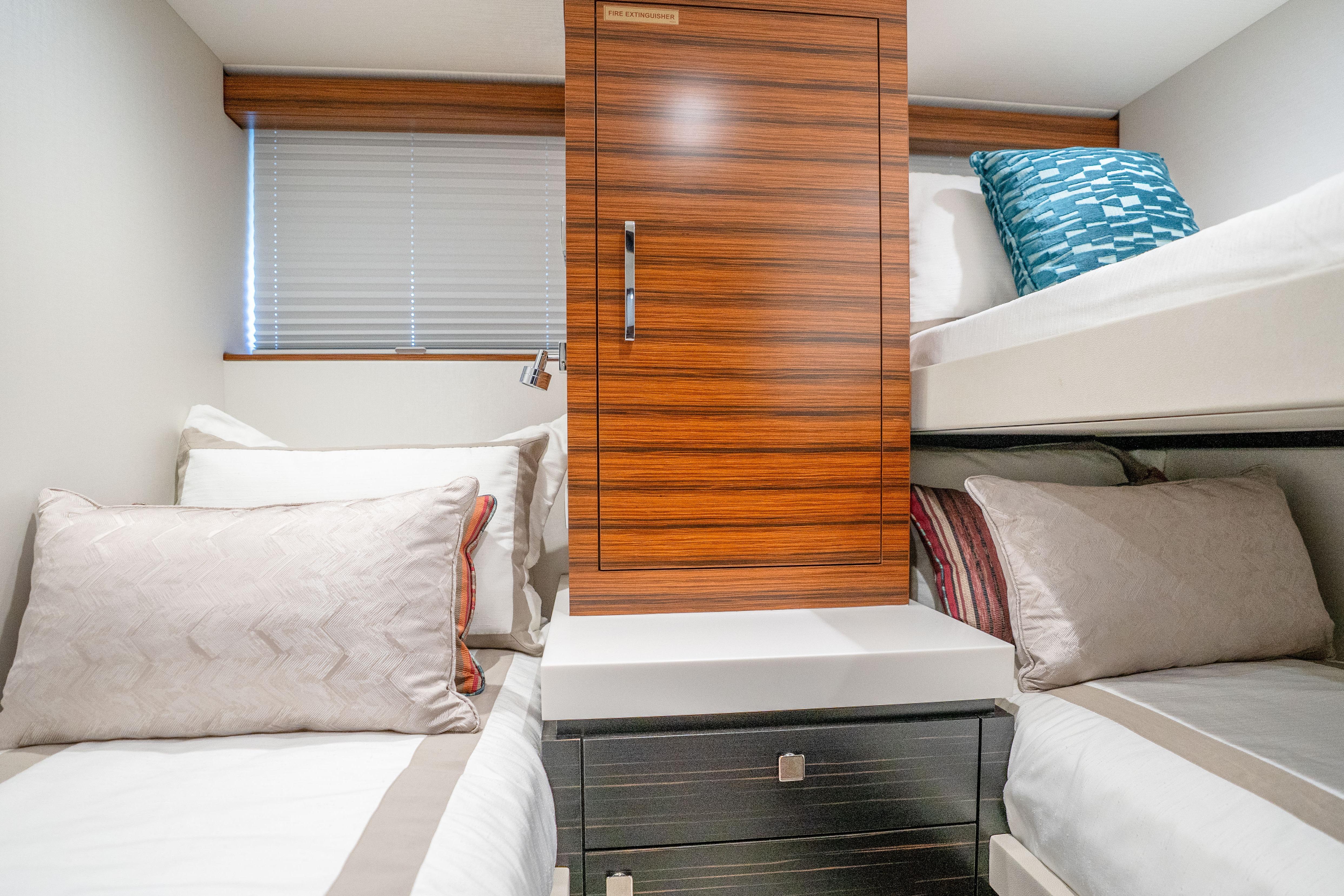 Luxurious cabin interior of 2021 Hatteras M75 Panacera yacht with twin beds and modern decor.