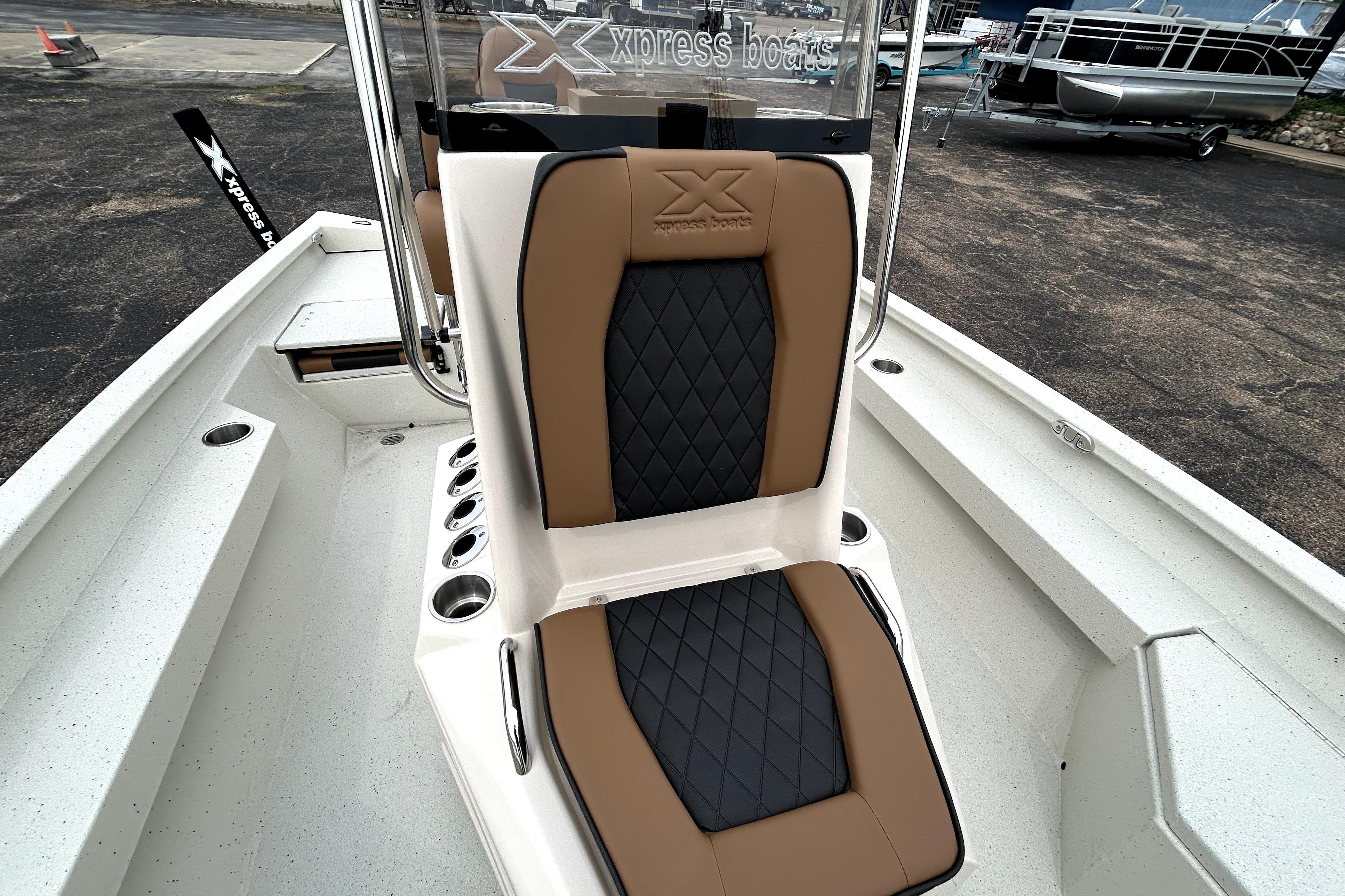 2026 Xpress H20B Bay boat with tan and black seating, docked outdoors.