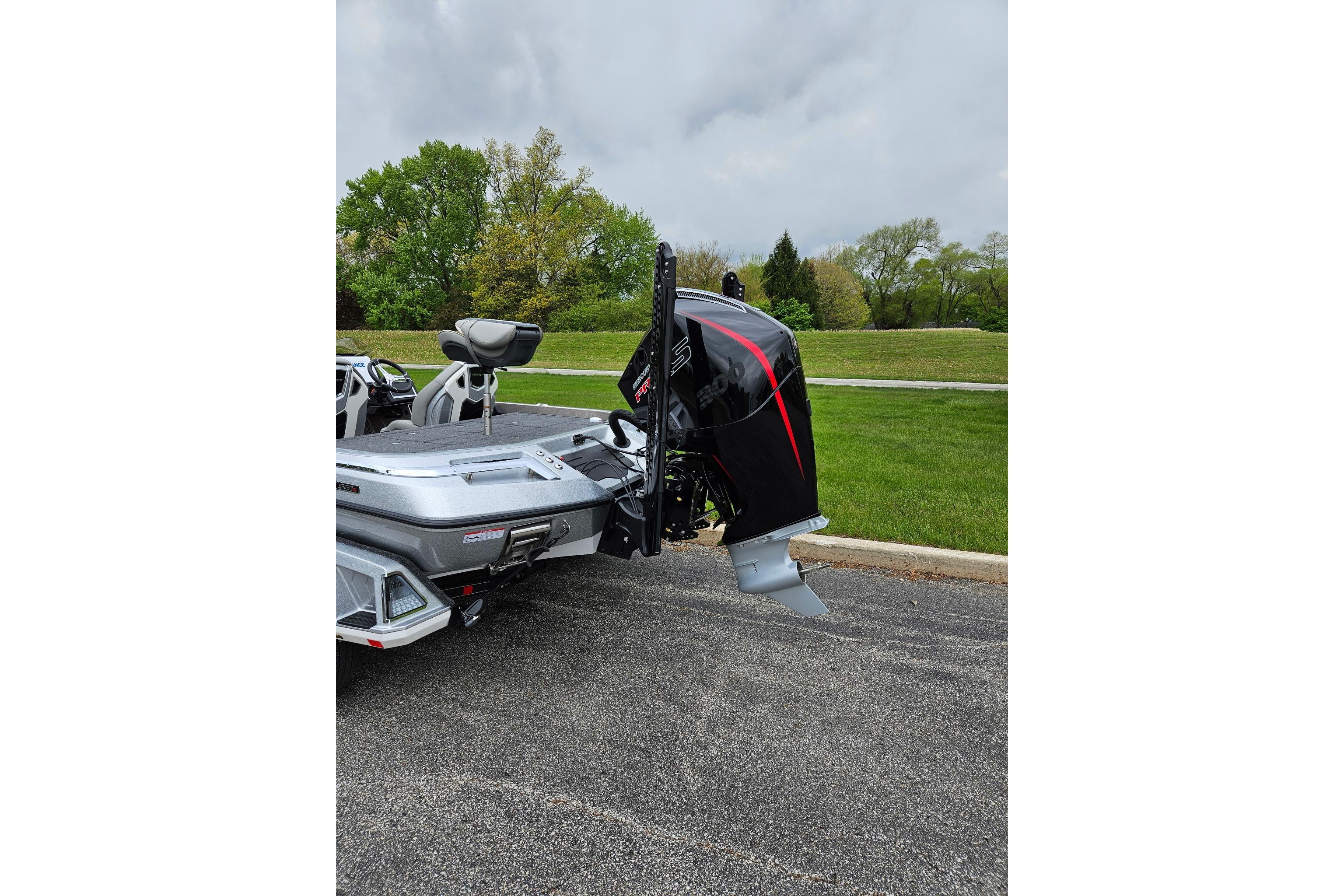 2026 Ranger Z521R Cup-Equipped boat with powerful outboard motor, parked on asphalt.