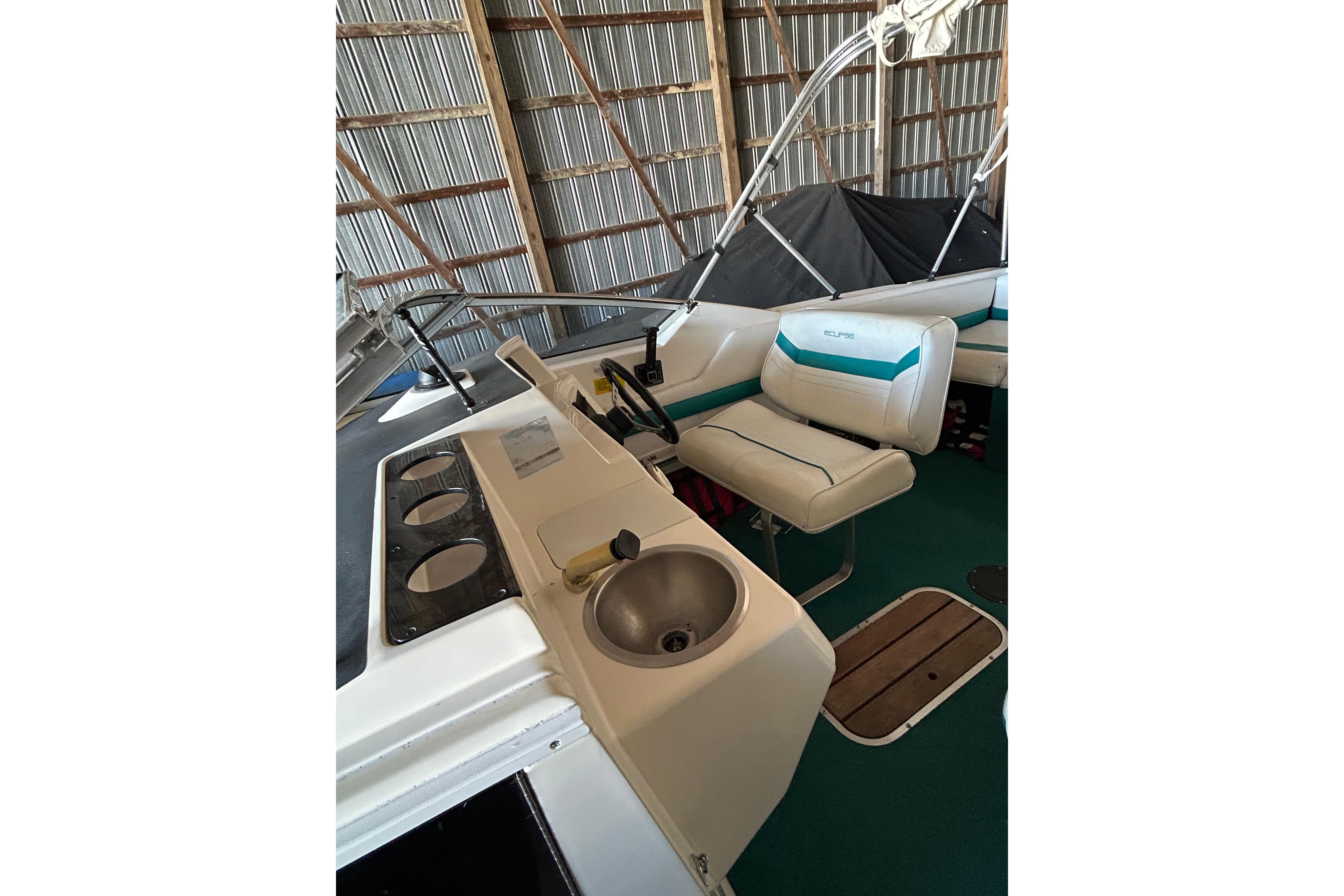 1991 Wellcraft 232 Eclipse boat interior with seating and sink in storage.