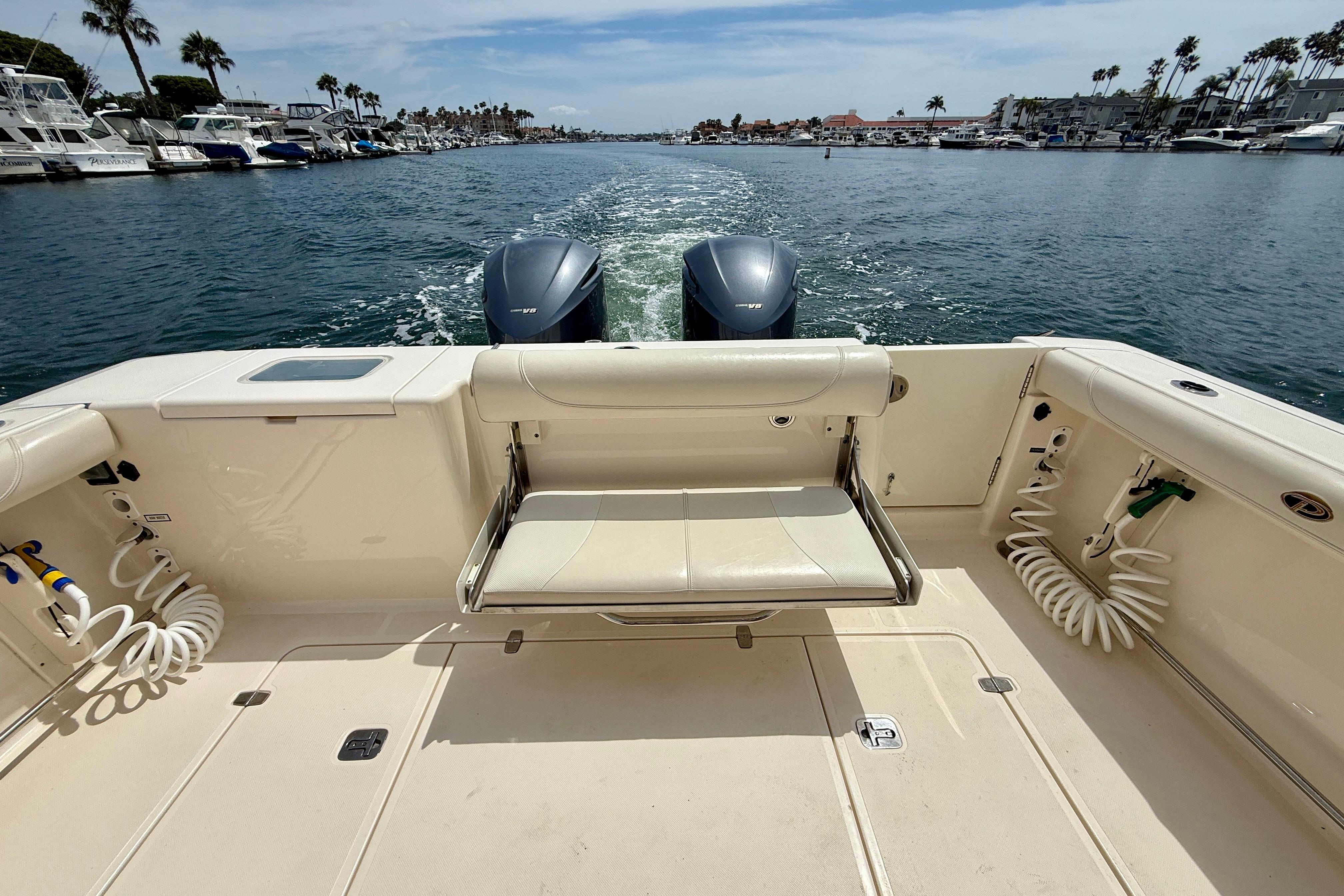 2012 Pursuit OS 345 Offshore boat with dual engines cruising in a marina.